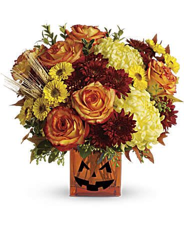 Halloween Glow Halloween Glow - This bouquet will get you in the Halloween spirit. Yellow chrysanthemums and festive orange roses are accented by eucalyptus and autumn oak leaves. Delivered in an orange cube vase with a jack-o-lantern face, it's the perfect Halloween costume -for your table! Yellow cushion spray chrysanthemums, bi-color orange roses, rust cushion spray chrysanthemums, yellow disbud chrysanthemums, yellow viking spray chrysanthemums are accented by oregonia, eucalyptus and autumn oak leaves for a lovely fall melody.