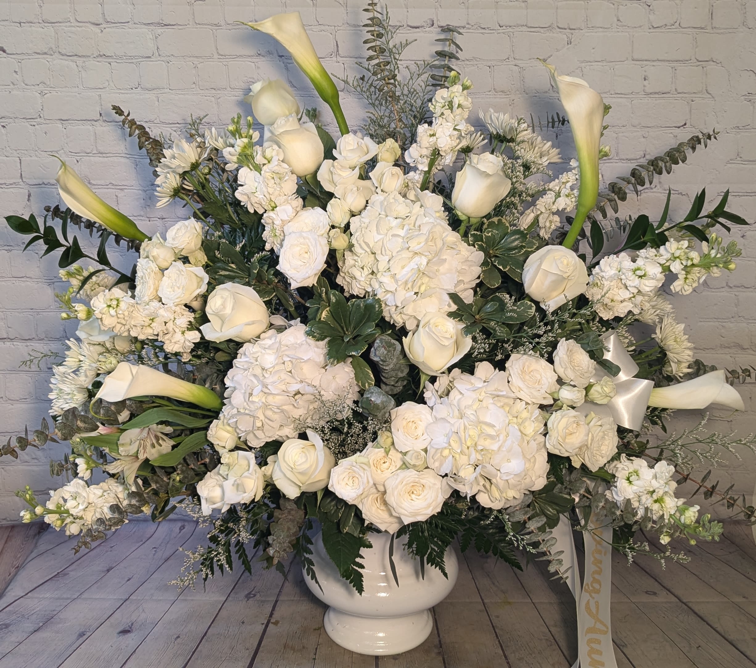 Eternal Affection Eternal Affection - Our grand Eternal Affection urn is a breathtaking display of all-white calla lilies, roses, hydrangea, stock, and spray roses. Designed as a heartfelt tribute, it honors a life well lived and deeply loved — a timeless expression of grace, purity, and enduring affection.