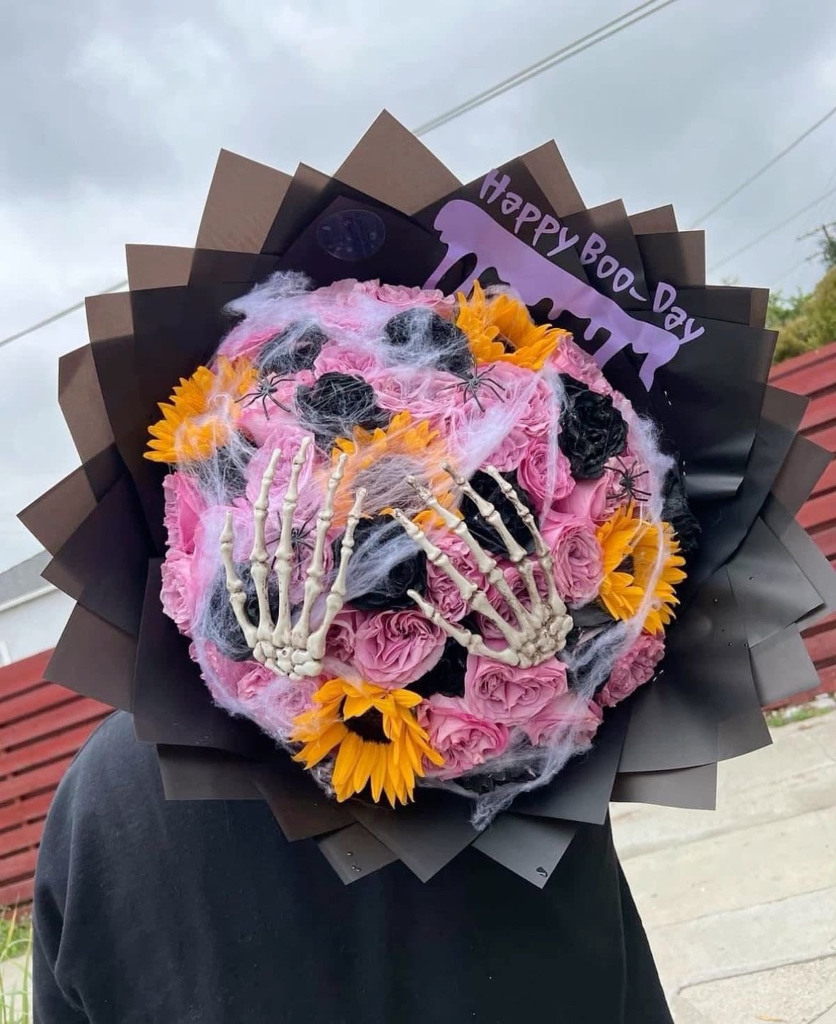 Happy boo-day bouquet  - Terrified of love she will be left with this cute bouquet of pink and black roses, accompanied by sunflowers, skull hands as an original touch, spider web and decorative spiders. Order today