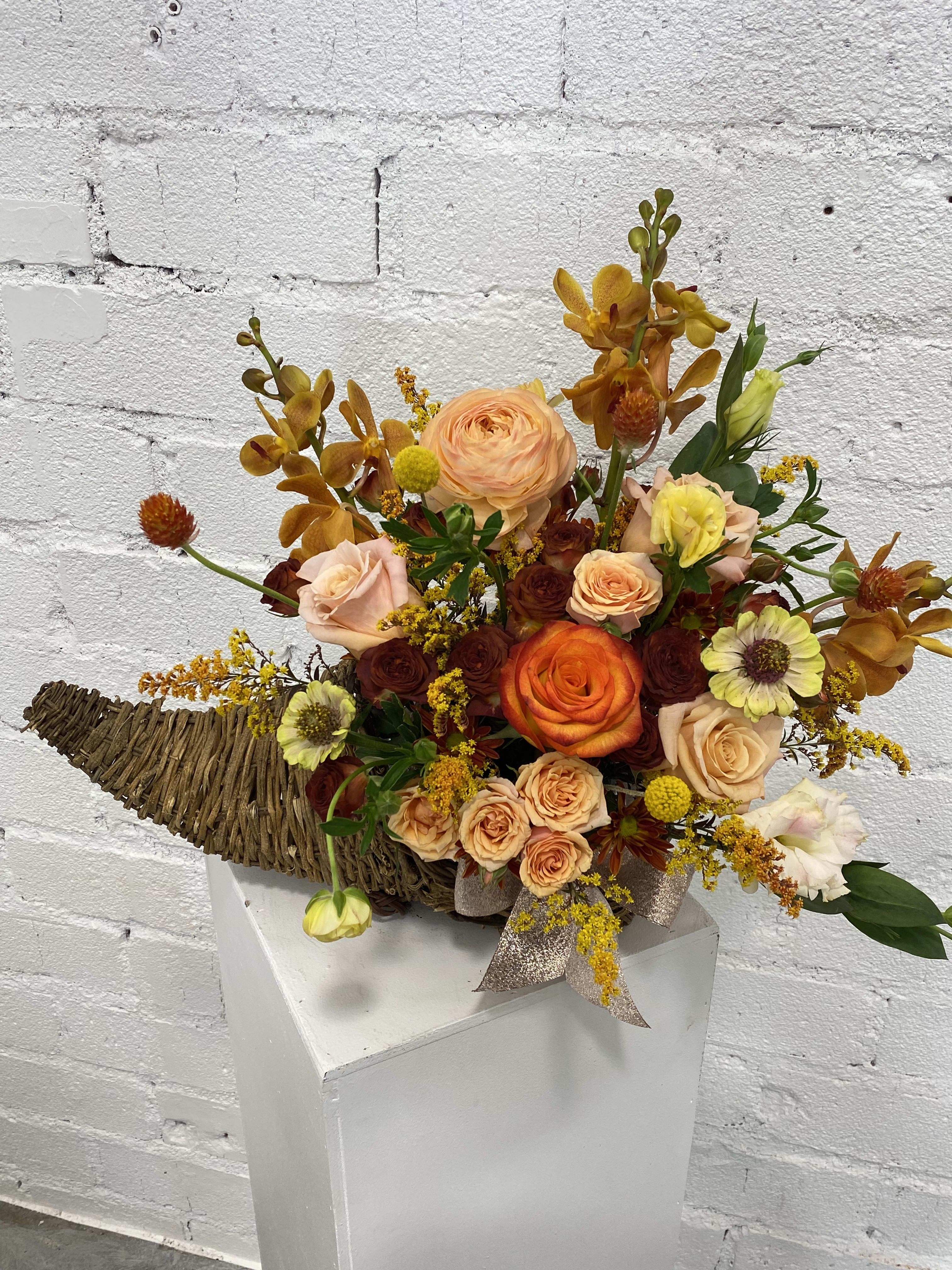 Cornucopia  Cornucopia  - Collection of fall flowers like orchids, ranunculus, roses, Lisianthus and other seasonal fillers in a cornucopia basket shape.