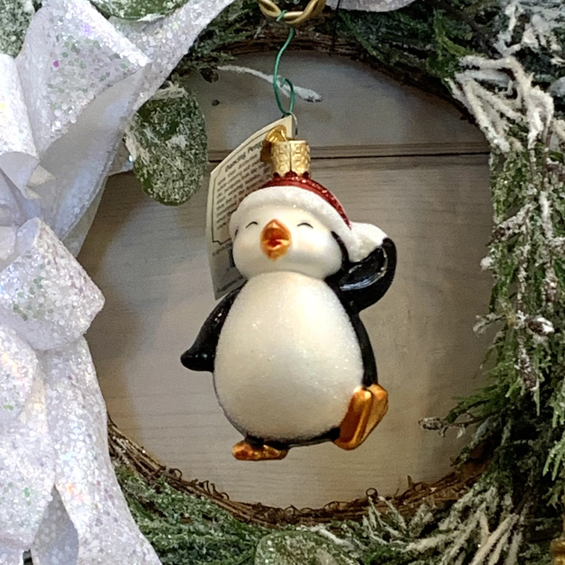 Dancing Penguin Dancing Penguin - With their distinctive black and white coloring and awkward waddle, penguins look like little comedians wearing tuxedos. Although they live in the Antartic, they are considered to be Santa's friends since these playful birds favor cold snow and ice. Approximately 3" tall and 2.5" wide. Each figurative glass ornament produced by Old World Christmas is hand crafted in age-old tradition using the same techniques that originated in the 1800s. Molten glass is mouth-blown into finely carved molds made exclusively for Old World Christmas, before a hot solution of liquid silver inpoured inside. The ornaments are then hand-painted and glittered in a series of labor-intensive steps to achieve our beautiful creations. Wreath and Tree Branch not included. For more ornaments please check out our store at 3882 Mayberry Dr Ste A, Reno, NV 89519