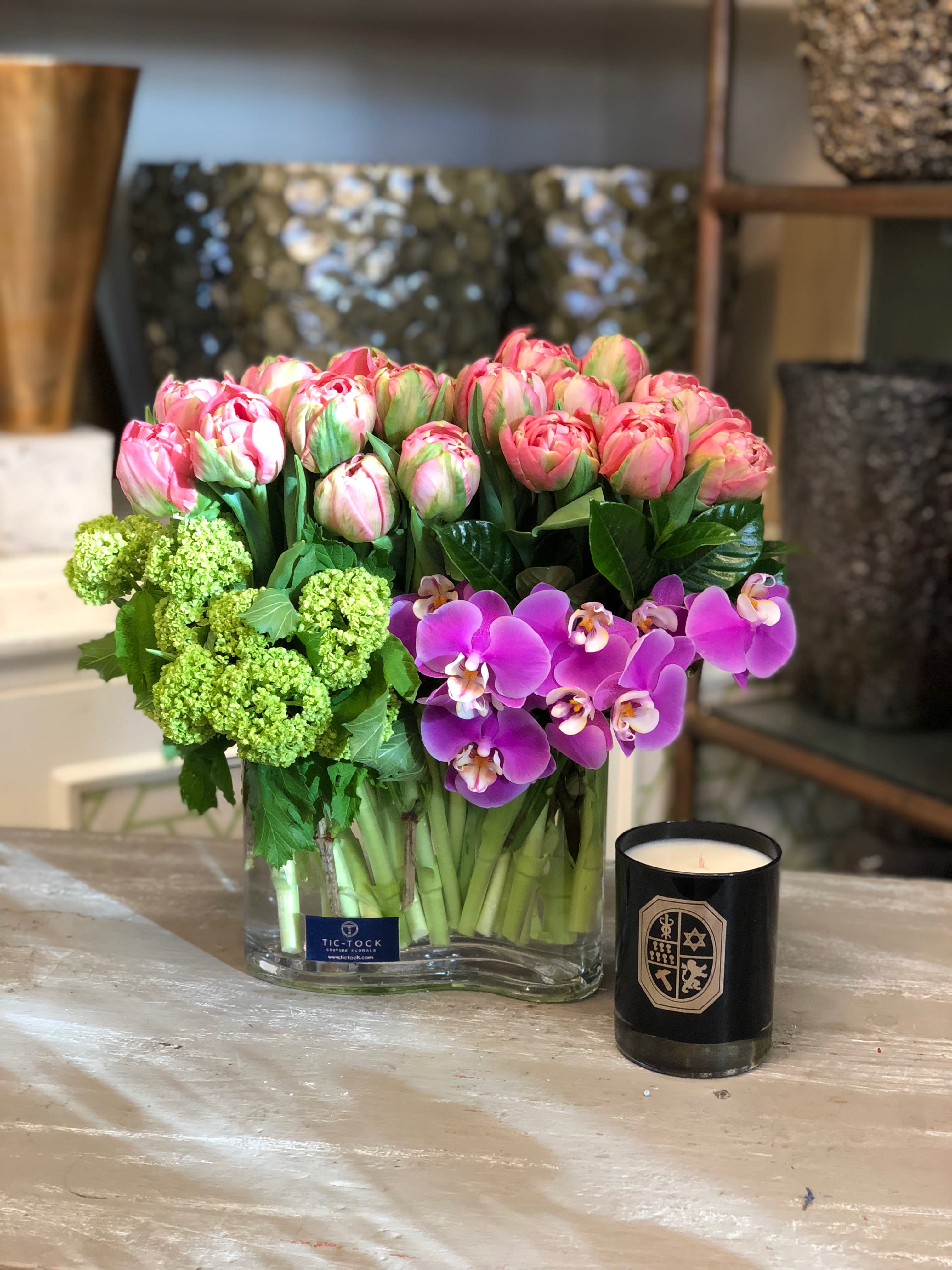 Lighten The Mood Lighten The Mood - A simple yet fun mix of tulips, orchids and viburnum, brings this modern piece to life.