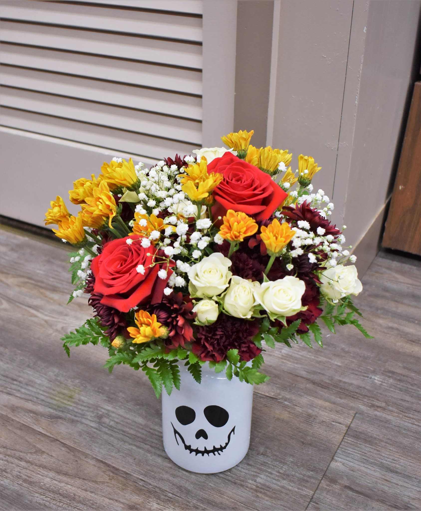 Spooky Scary Skeleton Spooky Scary Skeleton - ...A bouquet to send shivers down your spine! Bronze and burgundy mums, red roses, white spray roses, burgundy carnations, and fresh greens are designed in a glass skeleton vase...the perfect way to celebrate spooky season!