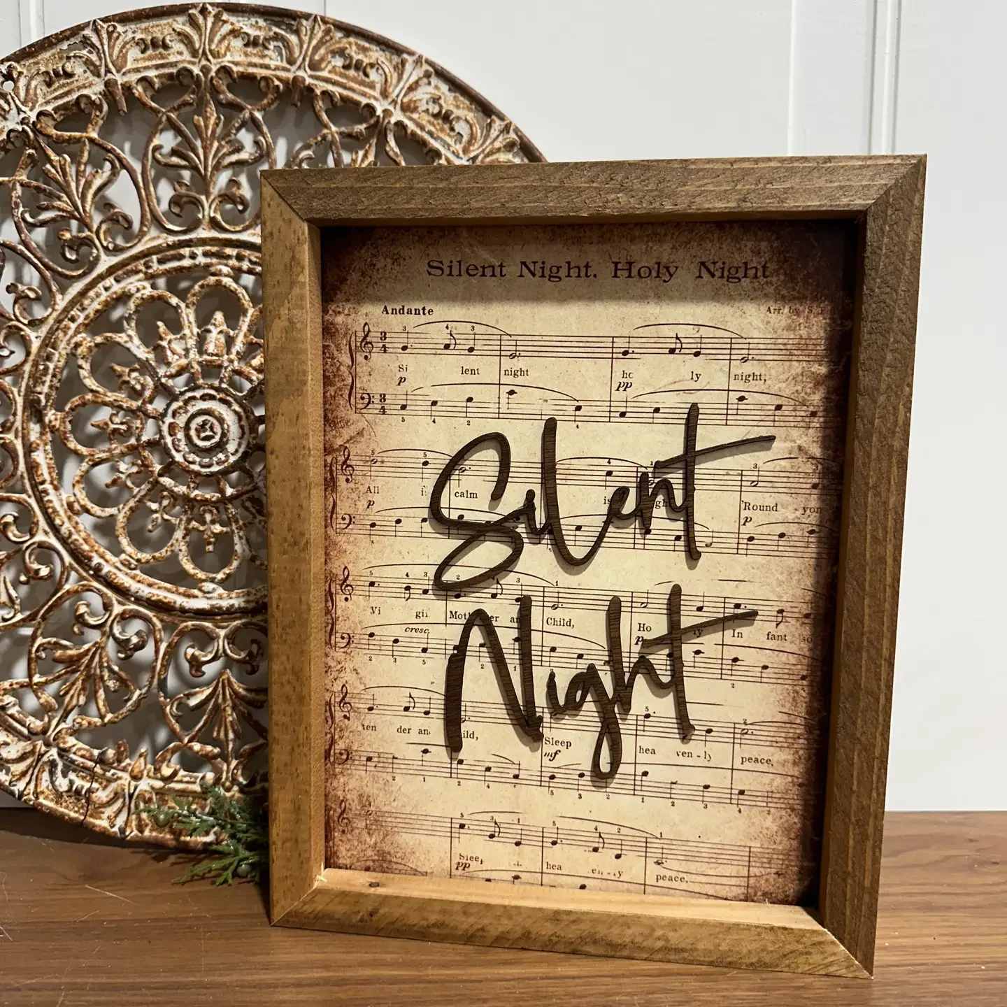 Silent Night Sheet Music Art Silent Night Sheet Music Art - Unique Design: The Silent Night sheet music is enhanced with a laser-cut “Silent Night” at the top, adding a beautiful dimension to the piece and making it a standout artwork. Vibrant Image: The photo is sublimated directly onto a sublimation board, ensuring a vibrant and high-quality image that captures every detail with precision. Custom Frames: The frames are crafted entirely in our workshop. Each frame is meticulously routed to hold the photo in place securely, offering a perfect fit and elegant finish. Dimensions: The image itself measures 8 x 10 inches, while the overall frame dimensions are 10 x 12 inches, making it ideal for wall display or as a striking tabletop piece.