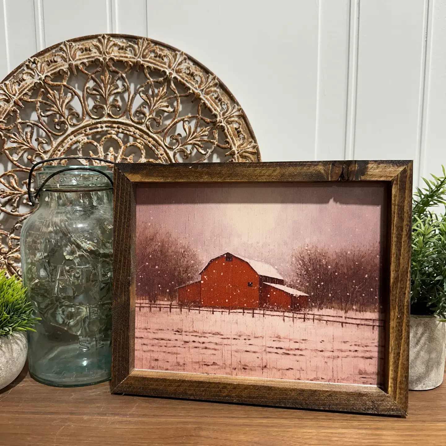 Snowy Barn Art Print Snowy Barn Art Print - The Snowy Barn Art Print is a serene and captivating piece of artwork that beautifully encapsulates the tranquility of a winter scene. The print depicts a charming barn blanketed in snow, with delicate snowflakes continuing to fall, creating a peaceful and picturesque landscape. Dimensions and Framing Print Size: 8x10 inches Overall Frame Measurement: 10x12 inches The piece is elegantly framed, enhancing its aesthetic appeal and making it ready to hang in any space. The frame complements the artwork, adding a touch of sophistication while protecting the print. Perfect for Any Space Whether you're looking to add a touch of winter charm to your home, office, or gallery, this Snowy Barn Art Print offers a timeless beauty that can be appreciated by viewers of all ages. Its peaceful depiction of nature in winter makes it an ideal choice for creating a calming atmosphere.The Snowy Barn Art Print is a serene and captivating piece of artwork that beautifully encapsulates the tranquility of a winter scene. The print depicts a charming barn blanketed in snow, with delicate snowflakes continuing to fall, creating a peaceful and picturesque landscape. Dimensions and Framing Print Size: 8x10 inches