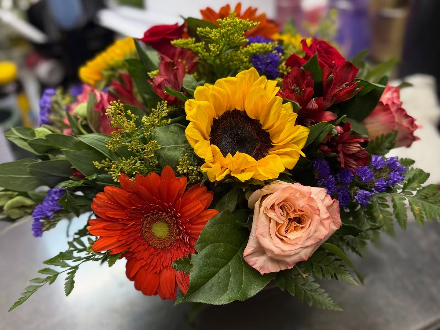 Fall in love with fall again Fall in love with fall again - We design the freshest gerber, roses and sunflowers in a contemporary vase and deliver this beautiful fall arrangement. If sunflowers are not available, we will substitute for a similar look and feel.