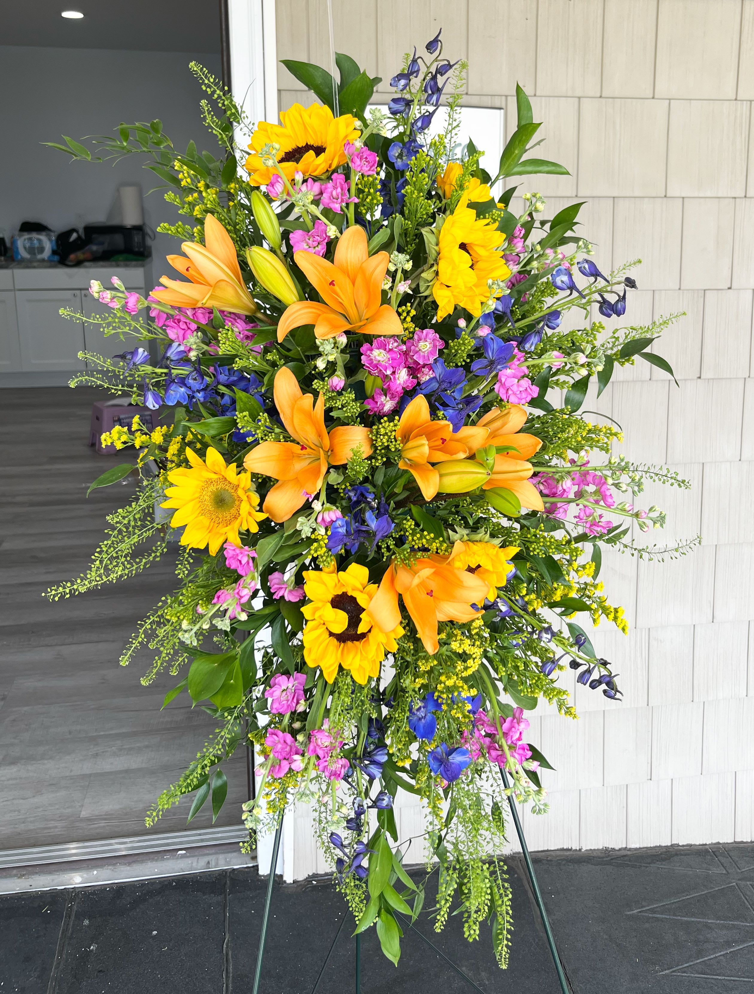 Sunlit Memories Standing Spray - Our Sunlit Memories™ Standing Spray is crafted with a mix of fuchsia, deep blue, hot pink and orange florals to celebrate their radiant life. This vibrant display combines bright shades with stunning texture while sharing thoughtful sentiments and comfort to loved ones.