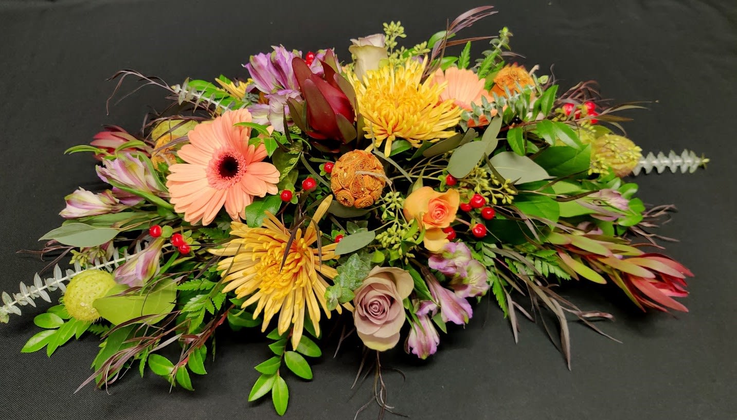 Long low medium autumn table centerpiece Long low medium autumn table centerpiece - Elegant with lots of texture. Berries, seeds, roses and beautiful fall foliage. Fun and interesting table centerpiece for Thanksgiving.