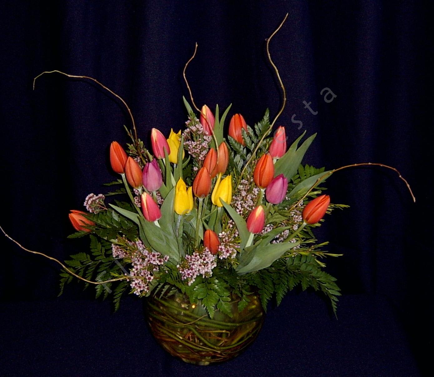 Large deluxe tulip bowl with willow Large deluxe tulip bowl with willow - Approximately 20 locally grown spring tulips arranged in a bubble bowl vase with filler flowers and curly willow branches. Colors may vary. Call well in advance to request specific colors. The bowl is full of winding willow branches to bring the interest all the way down to the bottom of this striking display. Our most popular valentine bouquet so ORDER EARLY as we sell out of tulips early