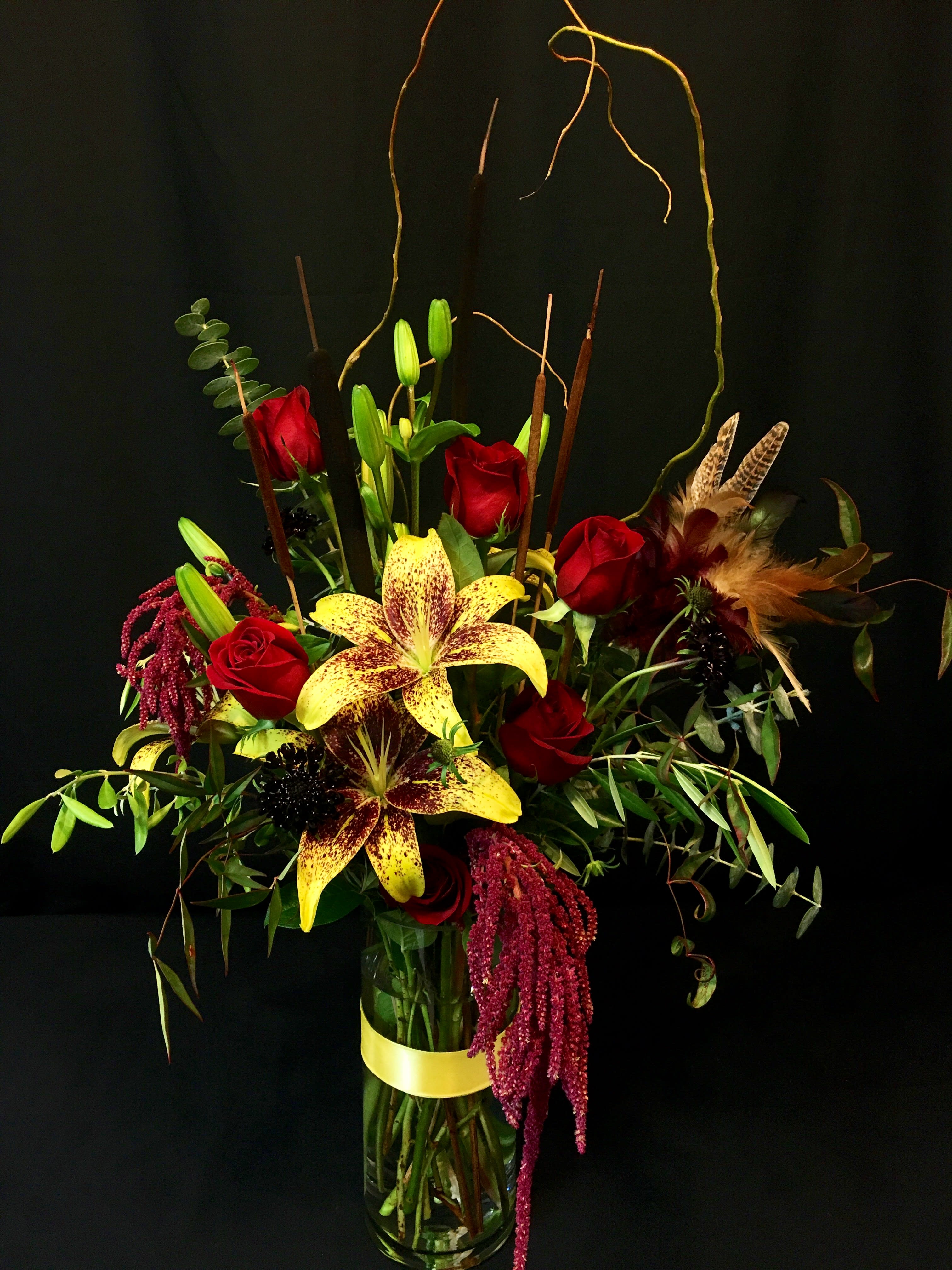 Roses and Feathers for Fall Romance Roses and Feathers for Fall Romance - Half dozen Long Stem Red or Burgundy Roses plus rich fall feathers, branches and bold lilies. Selection will vary somewhat from week to week.