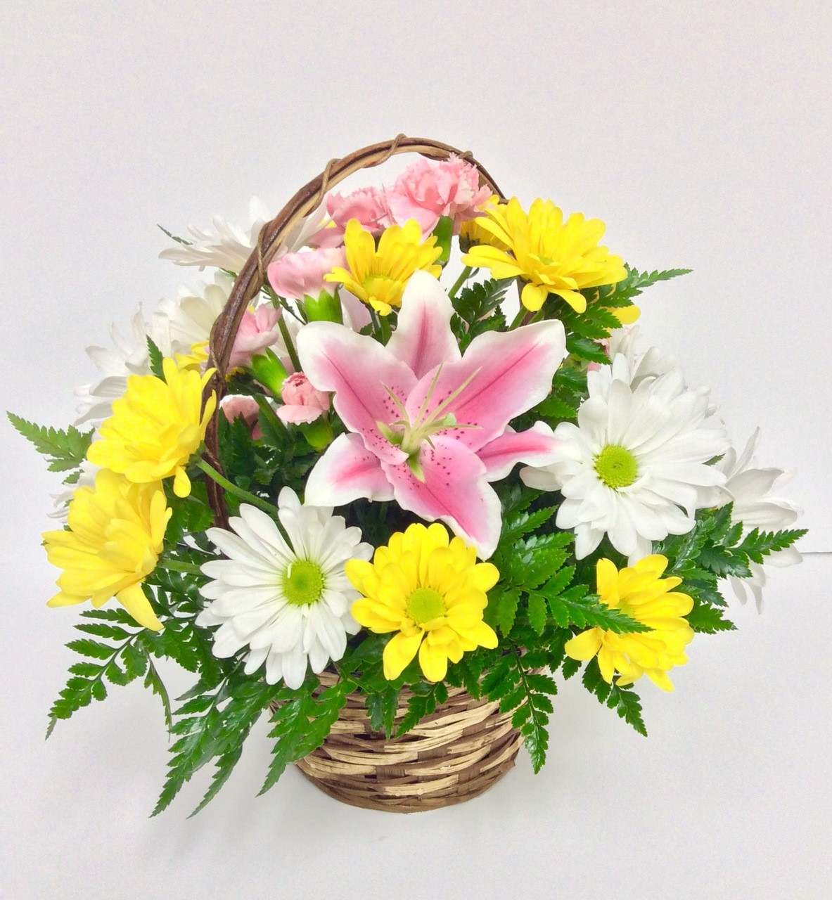 Small Sunny Basket Small Sunny Basket - Like a walk through a freshly mowed field, this lovely arrangement tickles one’s fancy while appealing to all the senses.  Celebrate someone you care about with this beautiful floral basket and see if it doesn’t put a bounce in their step! Arrangement includes pink oriental lilies, yellow and white daisies, pink carnations, and greenery. The container may vary depending on availability. Bouquet may be sent in a basket, a metal or a plastic container.