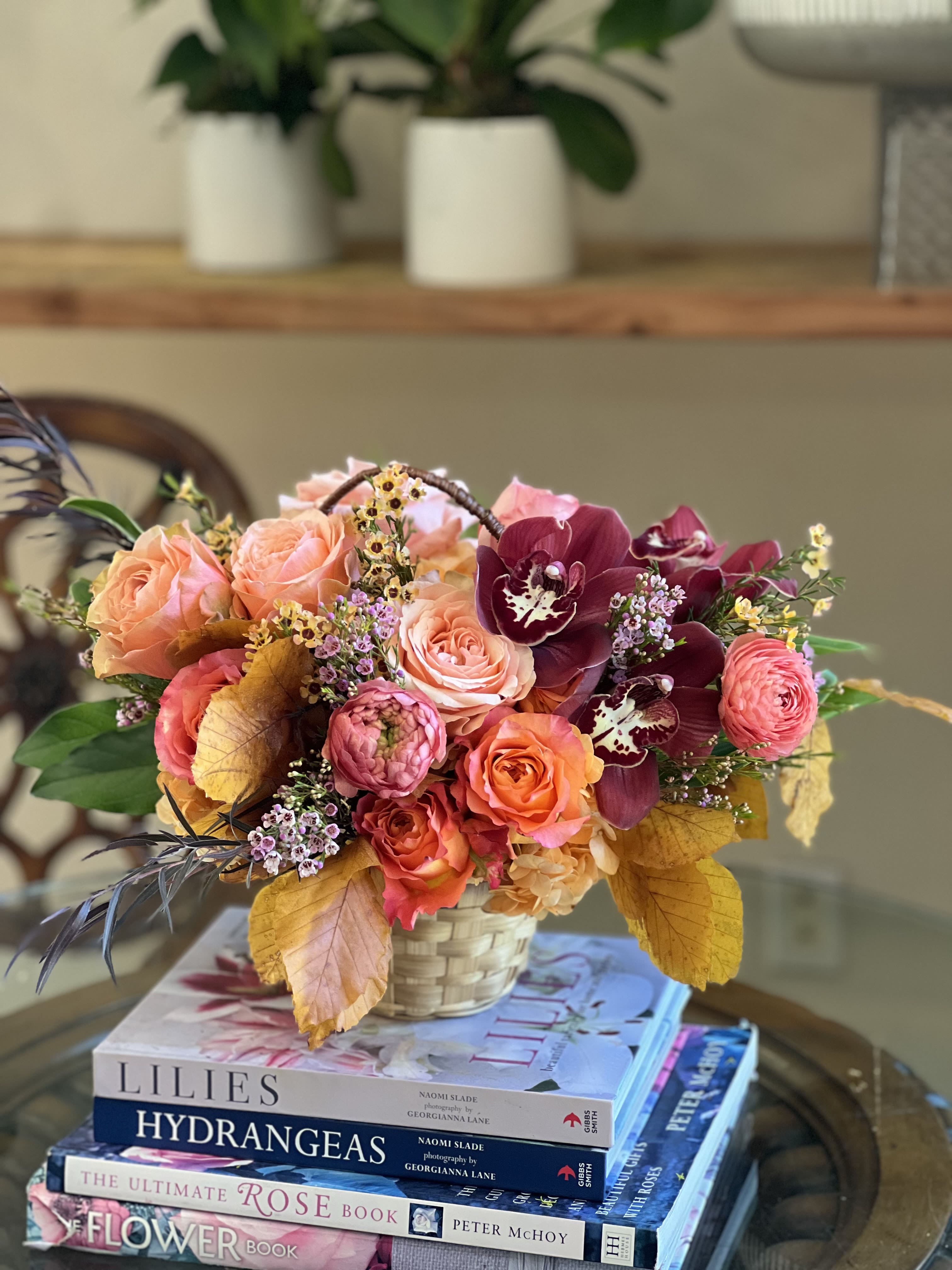 Autumn Rattan  Autumn Rattan  - Flowers: free spirit roses, orange ranunculus, kahala garden roses, copper beech tuscan leaves, burgundy cymbidium, waxflower, and willow eucalyptus.   Arranged in a rattan picnic basket