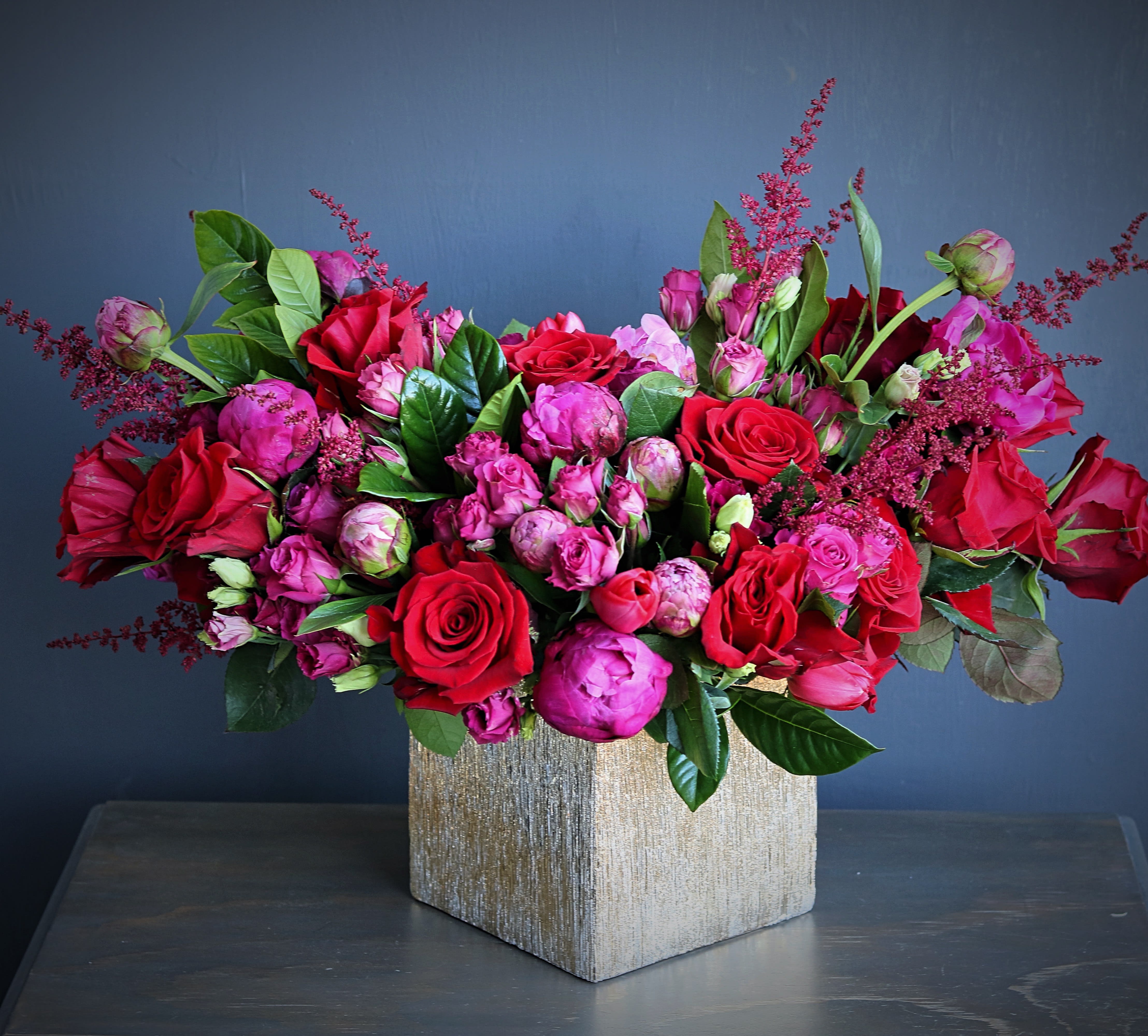 red and pink - This luxury arrangement contains mixed red and pink florals such as roses, peonies, spray roses, lisianthus and others, beautifully laid out in a square gold vase. Handwritten card is included. Send the most beautiful flowers for that special someone. Next day delivery available to Tequesta, Jupiter, Palm Beach Gardens and Palm Beach.