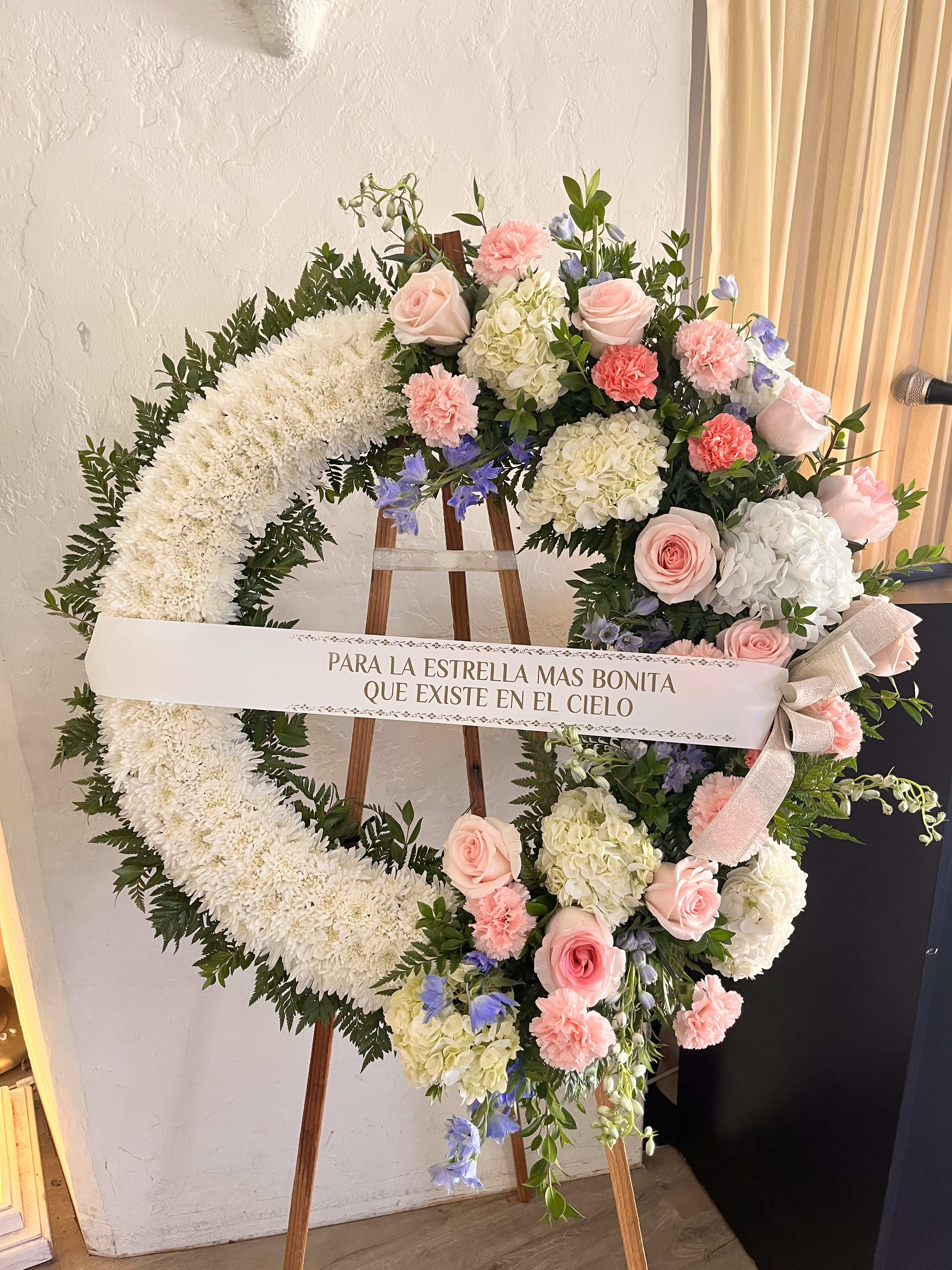 Twinkle Pink Wreath  - pink roses, carnations, delphinium, hydrangeas, various greens. 