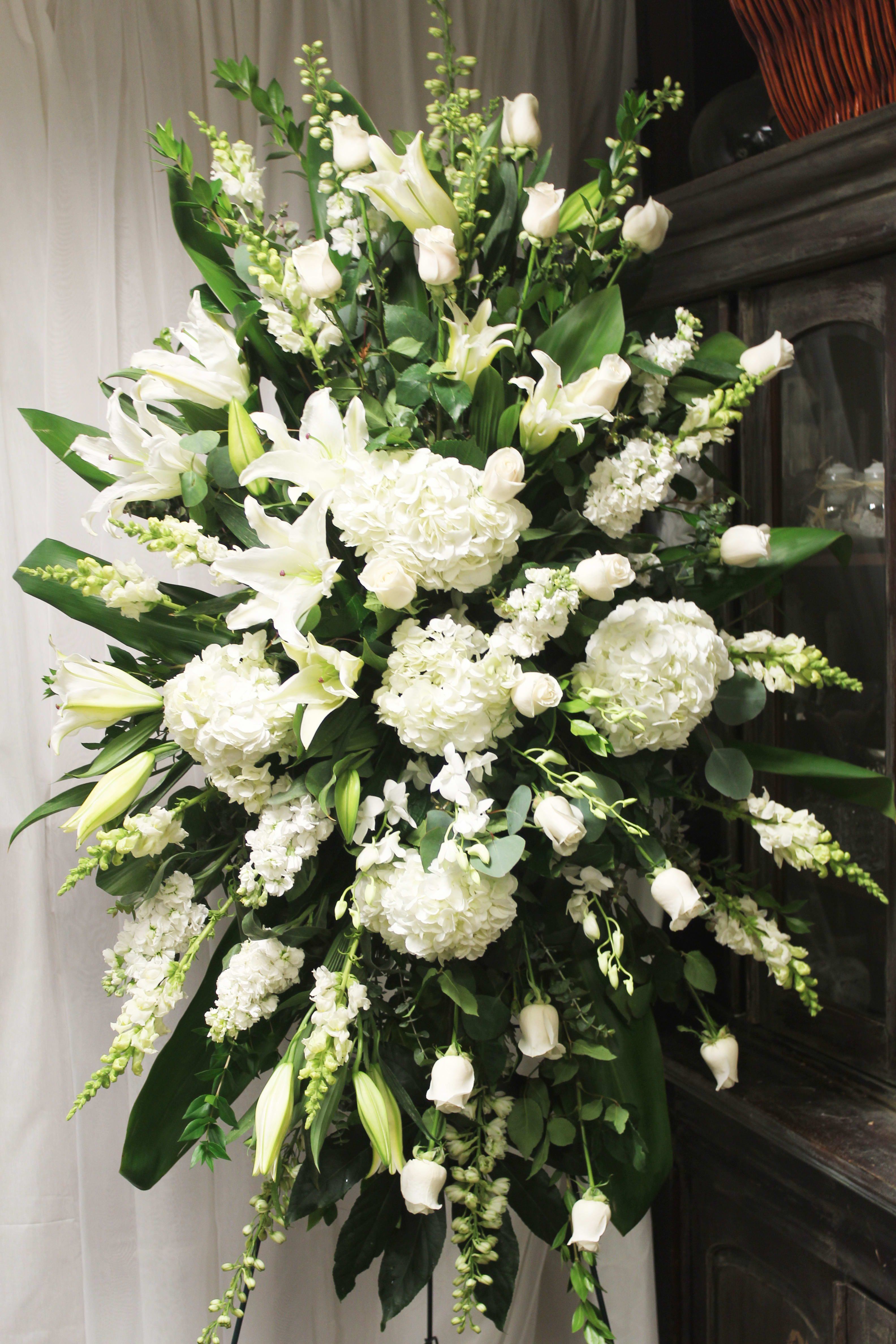 Majestic Tribute - A truly dignified and grand spray of white blossoms to celebrate the life of those who had hearts just as large.   Key notes for this design are orchids, hydrangeas, roses, white flowers, a spray, and easel. 