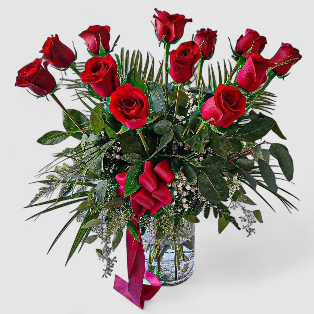 Dozen Long Stem Red Roses - Send this elegant and classic beauty today to show them how much you love them. One dozen long stemmed red roses arranged in a tall modern glass cylinder vase adorned with a pretty red satin ribbon bow. Stunning and the perfect way to make their day. Perfect to send for so many reasons. Always made extra special. Why not go for two dozen and witness happiness overload.