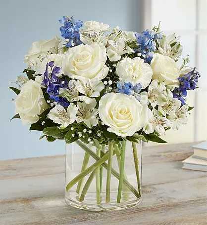 fancy boquet - All-around arrangement with white roses, carnations and Peruvian lilies (alstroemeria); blue delphinium; accented with baby’s breath and assorted greenery Artistically designed a clear glass cylinder vase Extra large arrangement measures approximately 16&quot;H x 14&quot;W Large arrangement measures approximately 14&quot;H x 13&quot;W Medium arrangement measures approximately 12&quot;H x 11&quot;W Small arrangement measures approximately 12&quot;H x 9&quot;W Appropriate to send to the home of family or friends Our florists hand-design each arrangement, so colors, varieties and container may vary due to local availability To ensure lasting beauty, Peruvian lilies may arrive in bud form and will fully bloom over the next few days