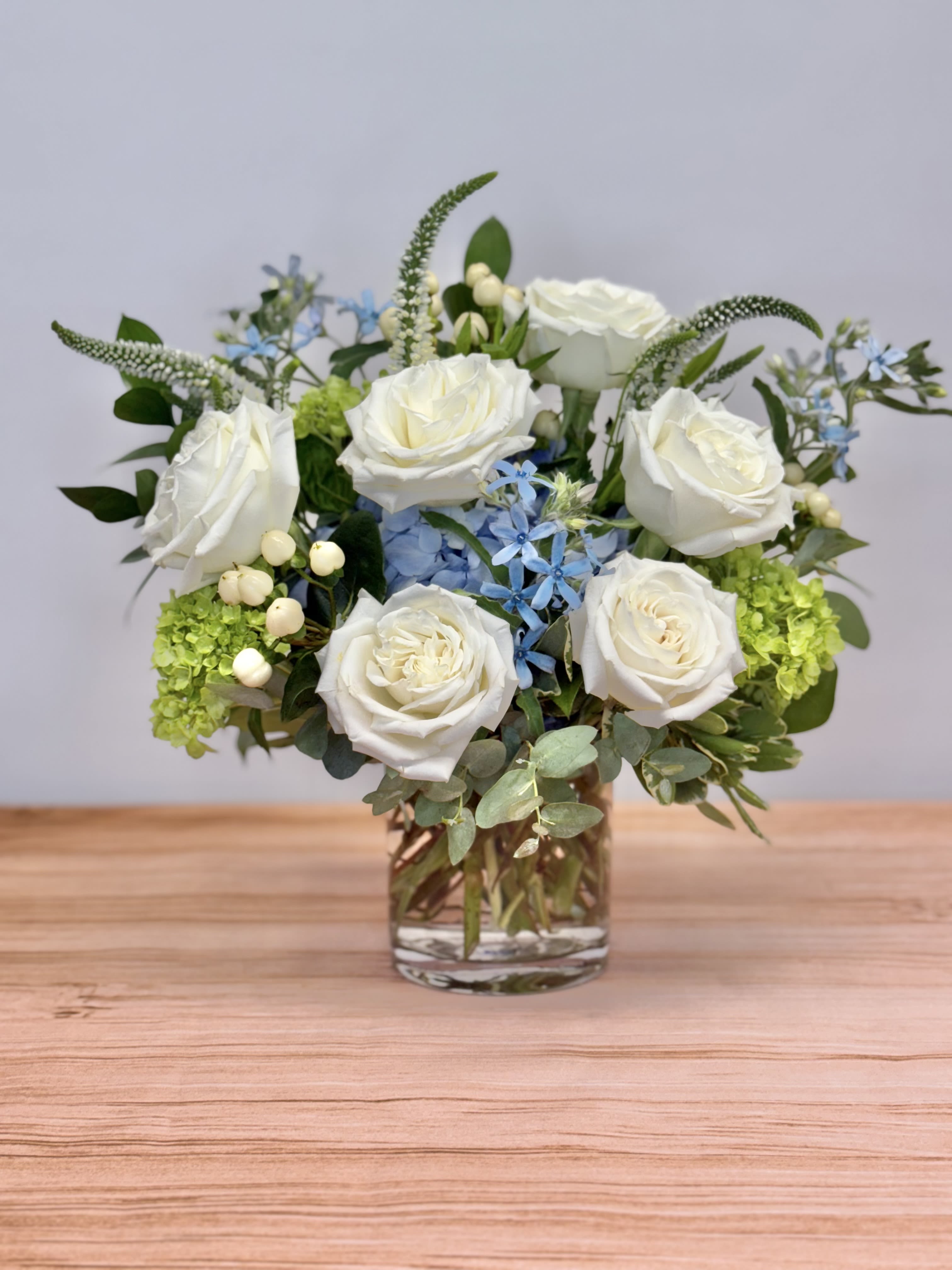 Sea Breeze Sea Breeze - Indulge in the tranquil beauty of our Sea Breeze bouquet. This exquisite ensemble features a delightful mix of blue hydrangea, white roses and blue tweedia.