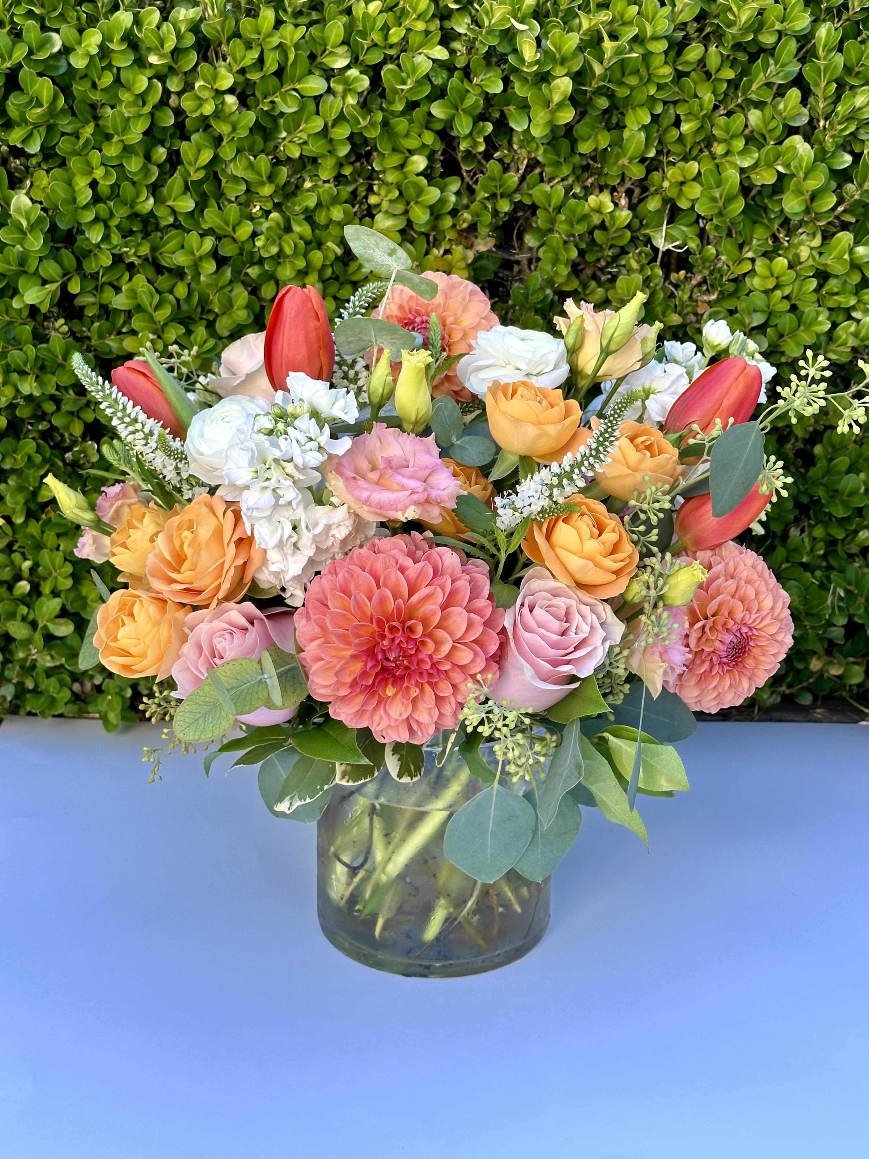 Bay Breeze - Featuring orange dahlias, pink roses, lisianthus, fragrant stock, and seasonal summer blooms.The perfect gift for any occasion.*** SHOWN IN DELUXE***