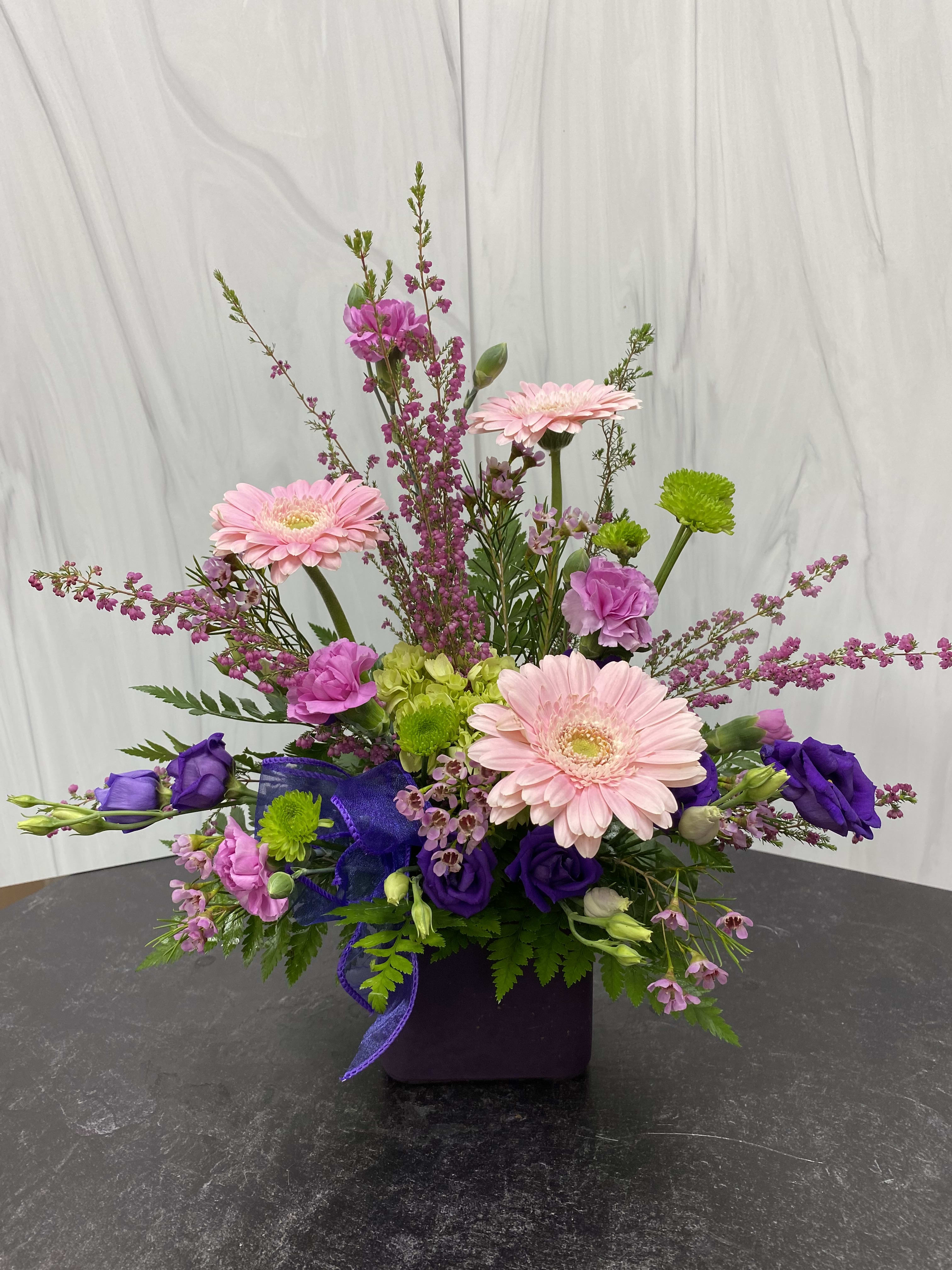 Crazy About Mom Crazy About Mom - A small frosted cube in assorted colors showcasing pink gerber daisies, green buttons, purple lisianthus, green hydrangea, mini lavender blooms.