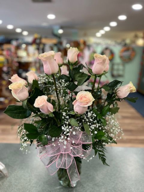 One Dozen Light Pink Roses (R12P) One Dozen Light Pink Roses (R12P) -  One dozen long stem light pink roses with assorted greens and accent flower finished with a coordinating bow.