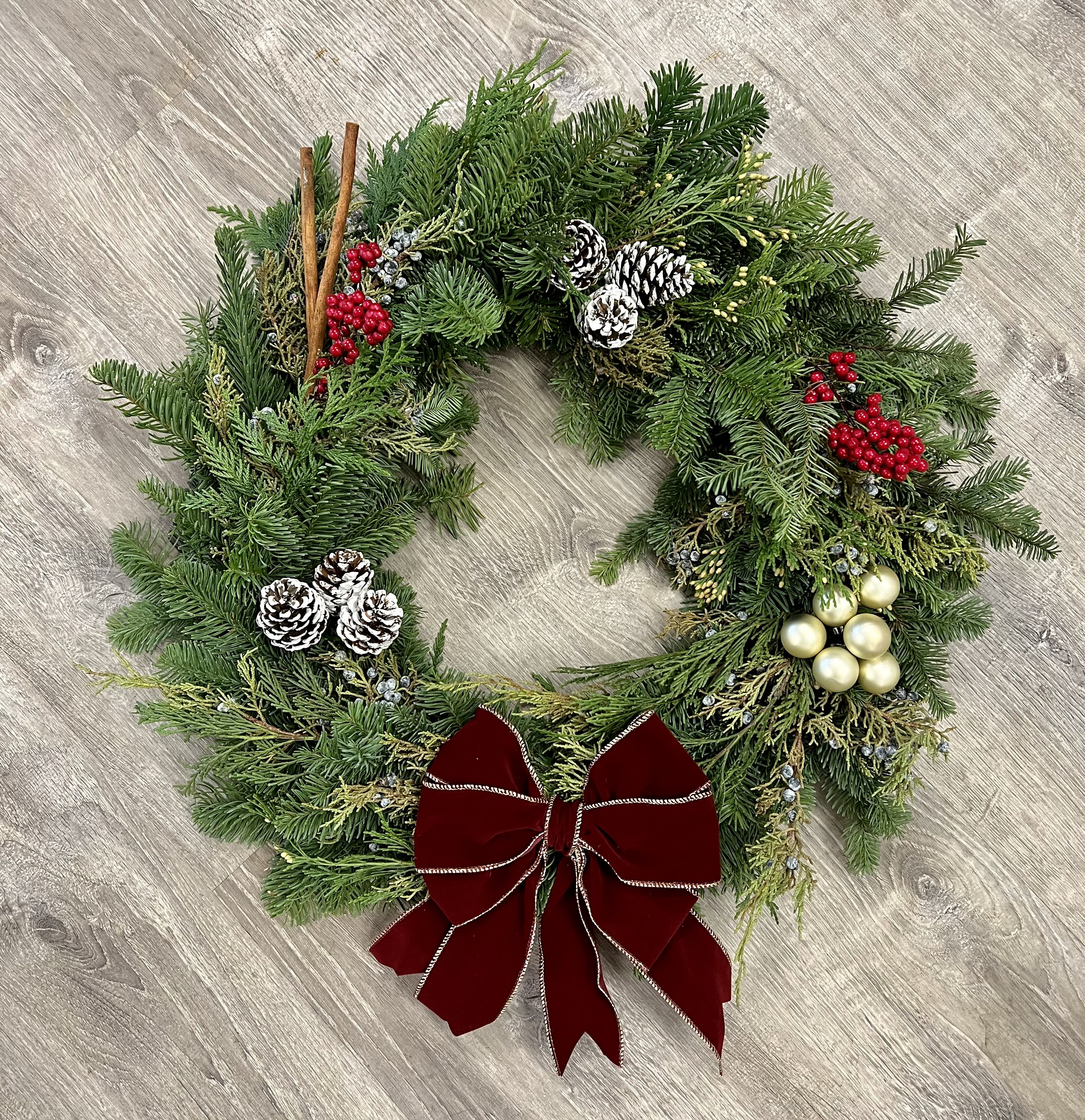 Winter Wreath Winter Wreath - A lovely outdoor wreath to last the holiday season! For the first time we are offering these for local delivery, so you can send a thoughtful and long-lasting gift. All wreaths including the evergreen base are handmade to order, so each will vary slightly, but they will consist of a mix of winter greens such as pine, fir, cedar, juniper, holly etc. and embellishments such as ornaments, pinecones, berries, cinnamon sticks, and bows. Please write in the comments if you have any specific requests for add-ons!