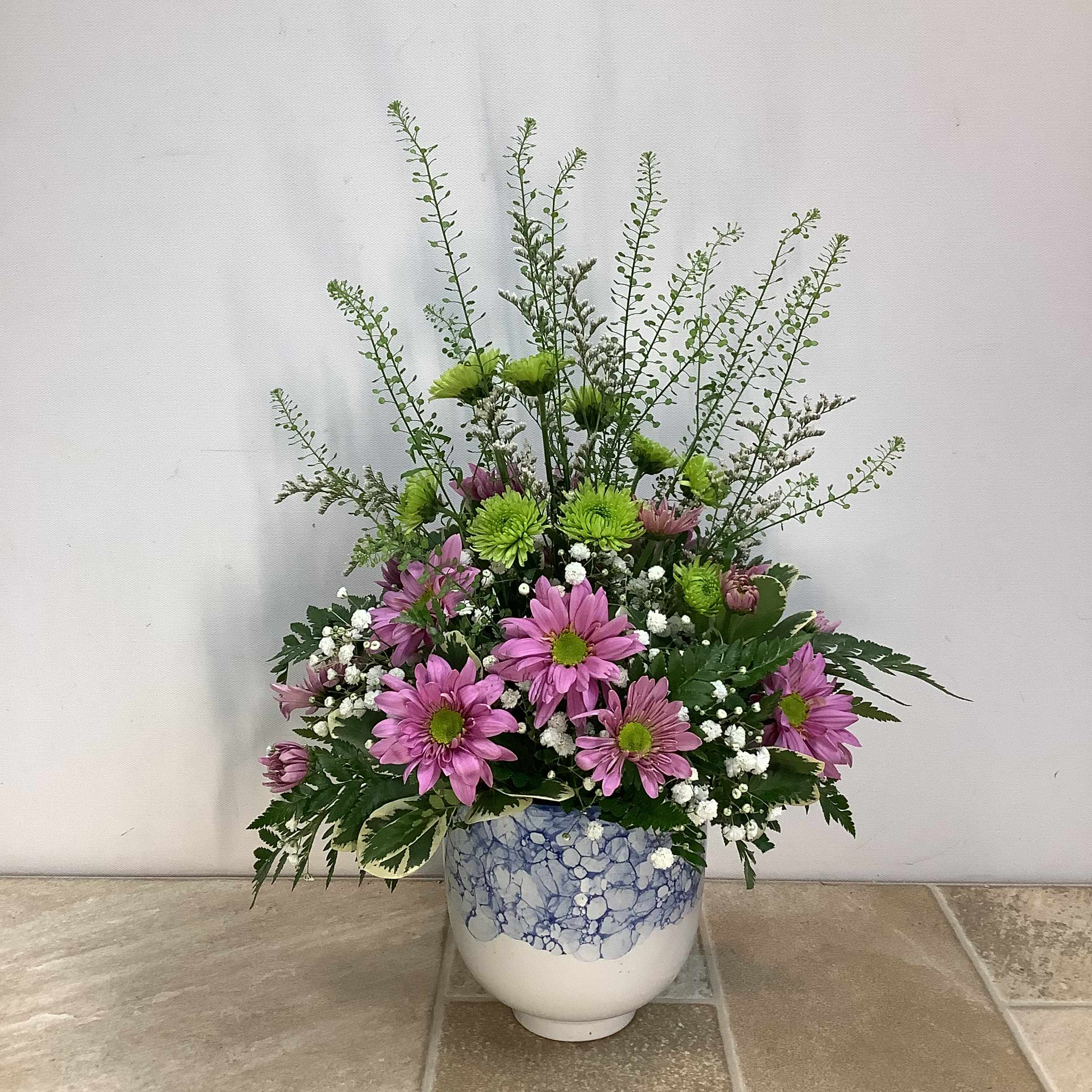A Pleasant Surprise A Pleasant Surprise - Make this bouquet “A Pleasant Surprise” for someone special today. Lavender daises, green athos, baby’s breath and pennycress are skillfully arranged in a VERY pretty ceramic vase. It’s perfect for any occasion and measures 14” wide x 17”high.