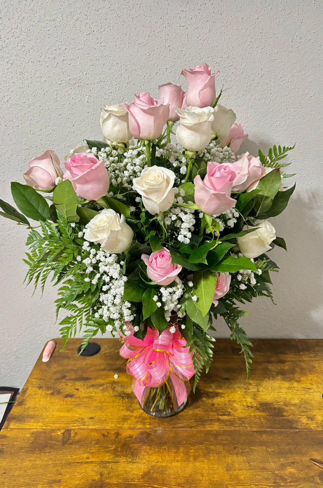 24 Pink and White Roses in Glass Vase - Graceful Blush &amp; Ivory Rose Vase Arrangement  Timeless elegance meets soft romance in our Graceful Blush &amp; Ivory Rose Vase Arrangement. This beautiful bouquet features a harmonious blend of delicate light pink and creamy white roses, perfectly complemented by lush greenery and baby’s breath. Arranged in a classic glass vase and tied with a charming pink ribbon, it’s a thoughtful gift for any occasion.  Whether you’re celebrating a birthday, anniversary, welcoming a new baby, or simply expressing love and appreciation, this arrangement brings grace and beauty to every moment.  Please note: Pink roses tone may vary slightly based on seasonal availability, but the overall look and feel will always reflect the soft, romantic theme.