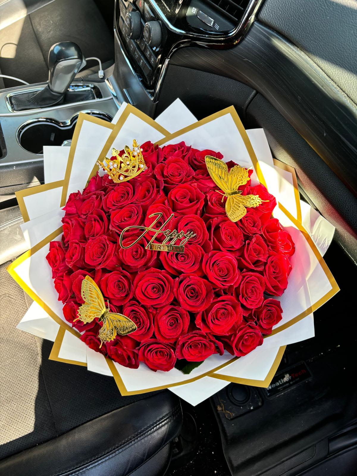 Happy Birthday 50 Rose Bouquet  - A stunning symbol of passion and sophistication. This Luxury Red Rose Bouquet with Gold Accents features an exquisite arrangement of premium red roses, wrapped in elegant white and gold paper for a regal touch. Adorned with delicate gold butterflies, a crown detail, and a “Happy Birthday” topper, this bouquet is perfect for making any celebration unforgettable.  Perfect for: Birthdays, anniversaries, romantic surprises, or any special occasion that deserves a grand gesture. Includes: Premium red roses, luxury wrapping, gold accessories, and customizable topper. Note: Wrapping paper is waterproof. Keeping it on is optional. Trim stems ½ inch at an angle and change water every 1–2 days for freshness.