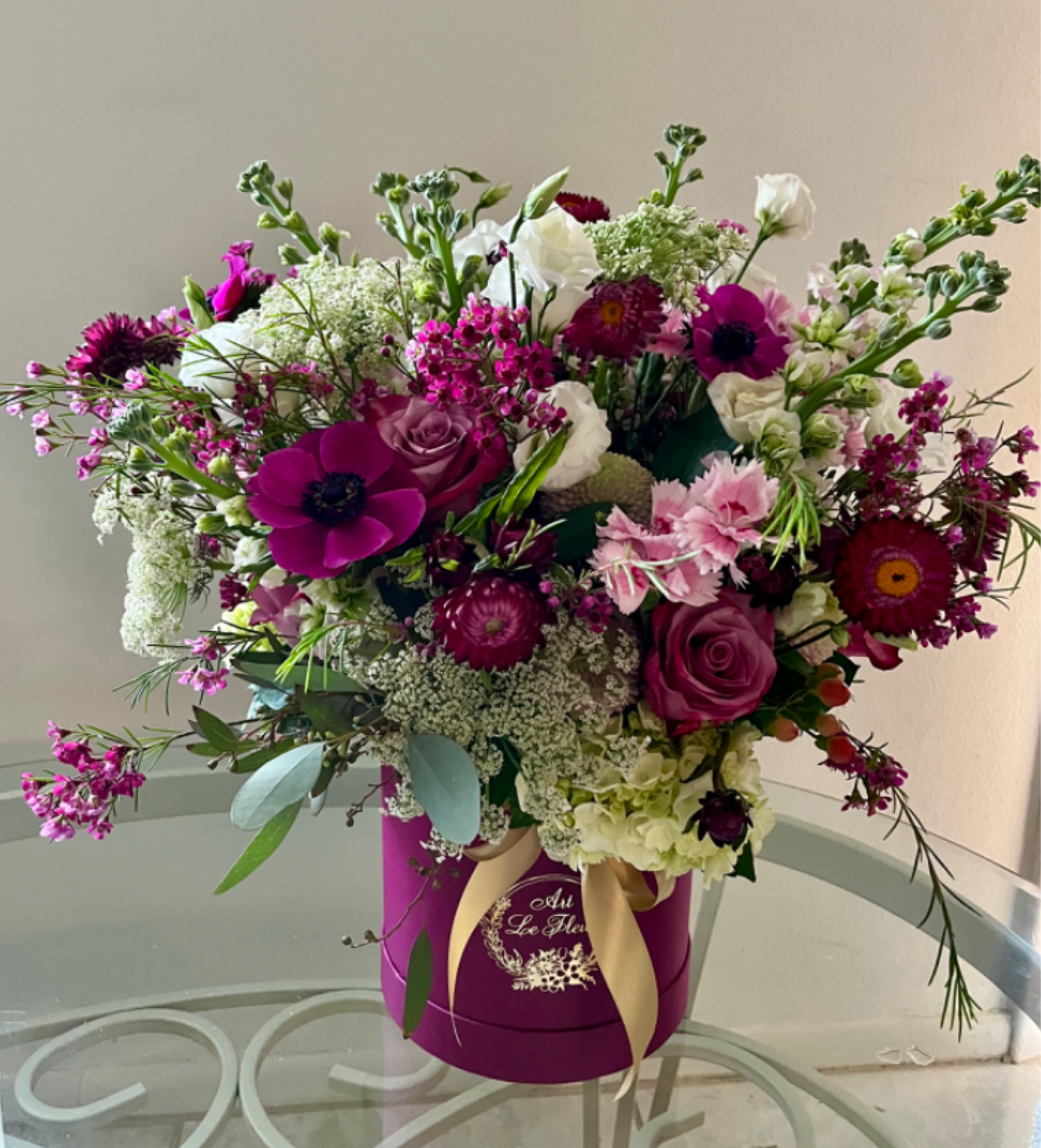 Boho Meadow Boho Meadow - A stylish hatbox filled with wildflower-inspired blooms in a boho, natural style. Effortlessly free and trendy, it captures the charm of nature with modern and chic elegance. Your personalized card is always handwritten and free with Art le Fleur.