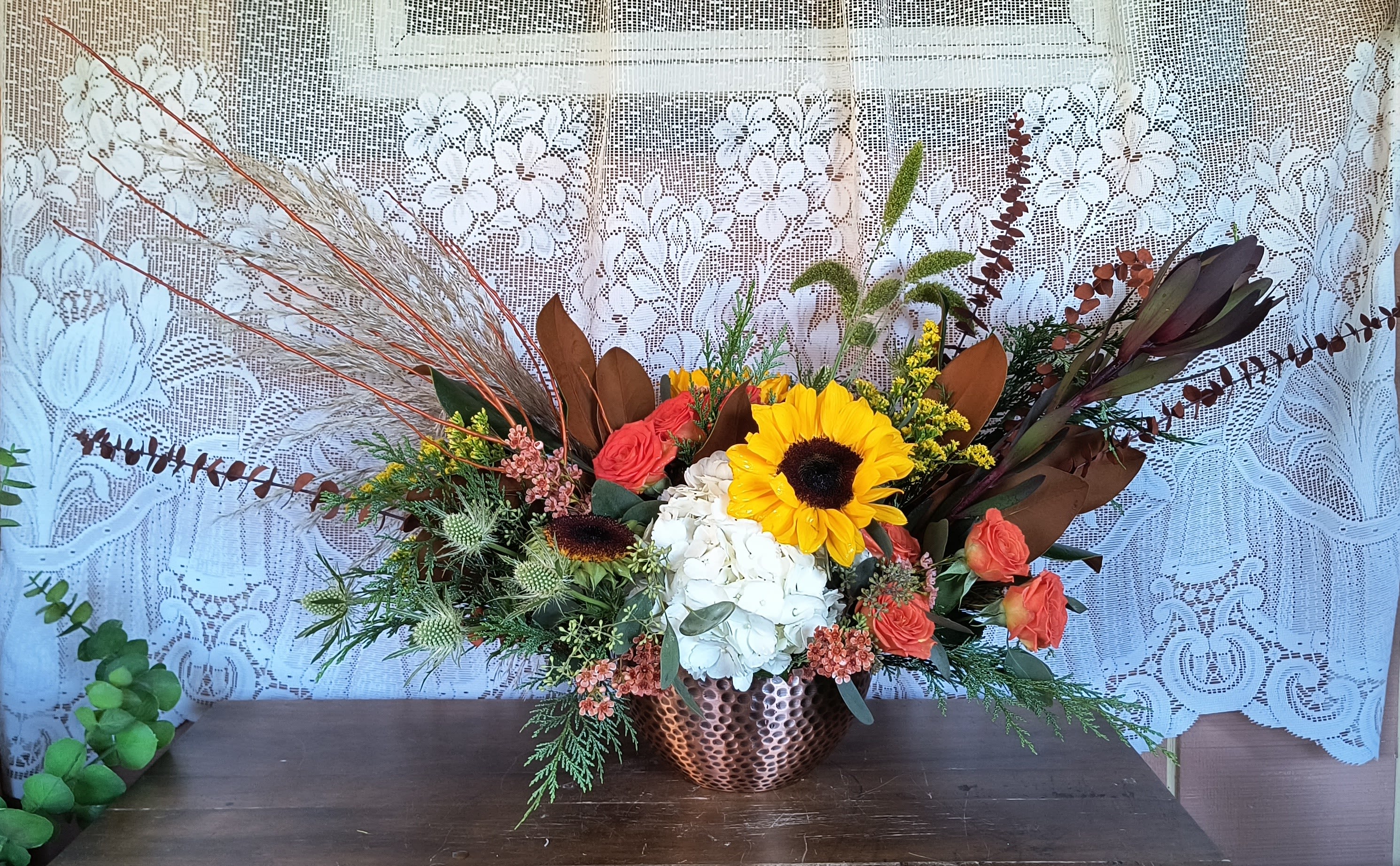 Glorious Glorious - An eclectic arrangement of autumn materials in glorious seasonal colors and flowers. This unique design will warm hearts. **Some content may vary depending upon availability.