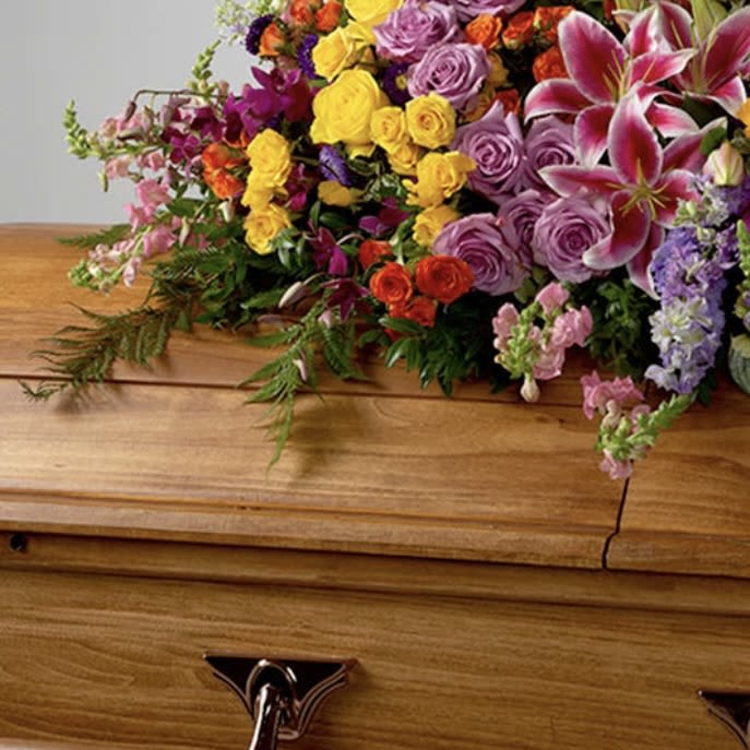 Everlasting Spring by BloomNation™  - A full celebration of colors, this multi-flower and bright casket spray is representative of a life lived to its fullest. Colors and flowers may change based off of season and availability. 