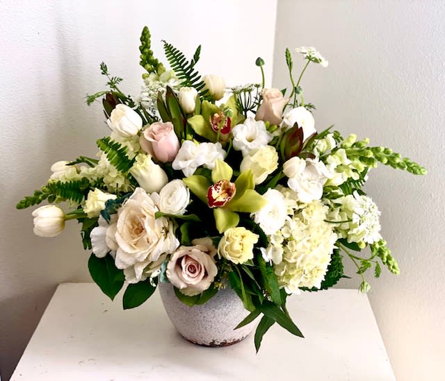Shangri La - A beautiful compilation of seasonal white flowers in a lovely ceramic antique vase.