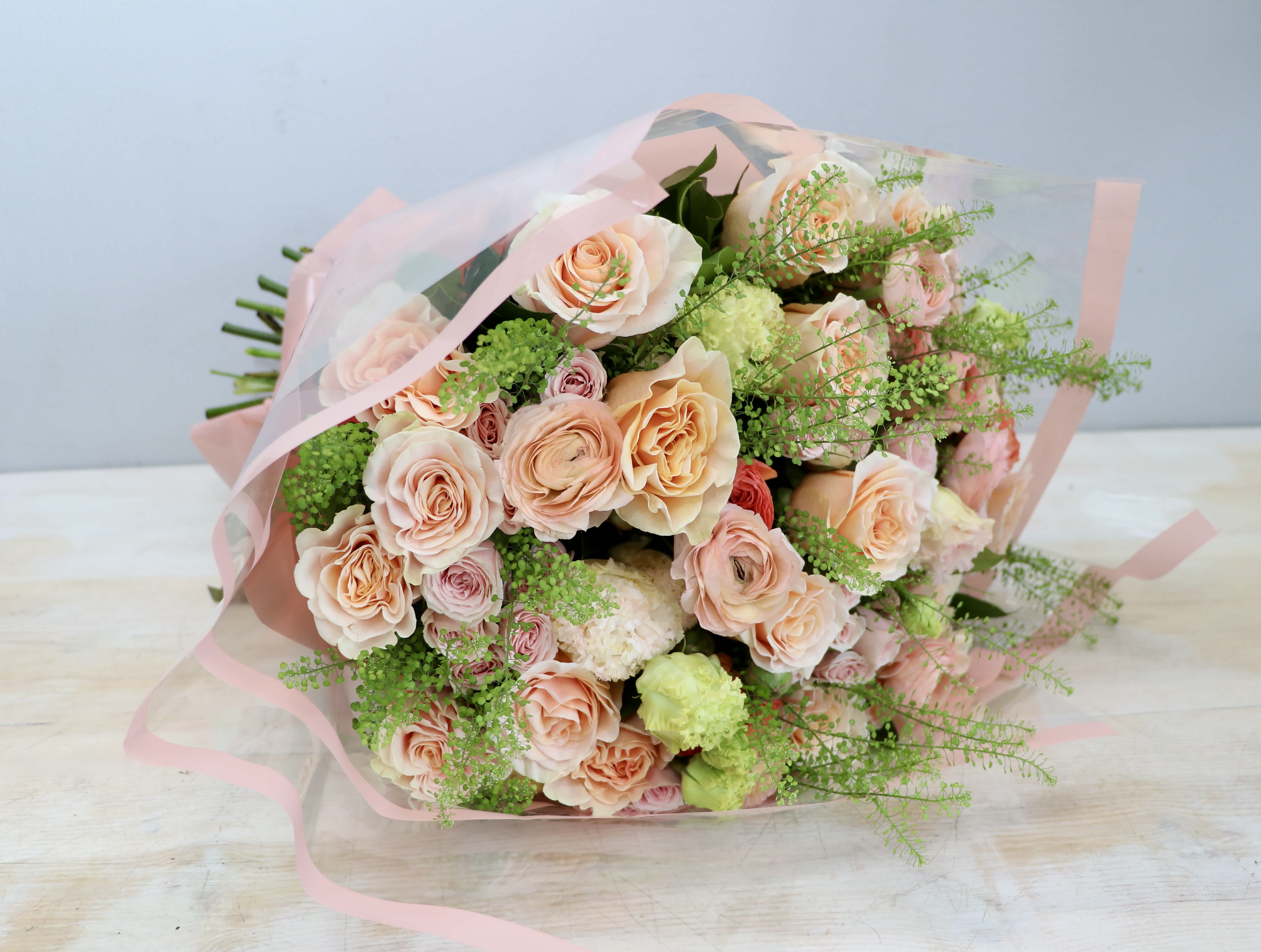Perfectly Peachy Bouquet - My Glendale Florist - This wrapped bouquet is made with peachy roses, pink spray roses, and lisianthus.