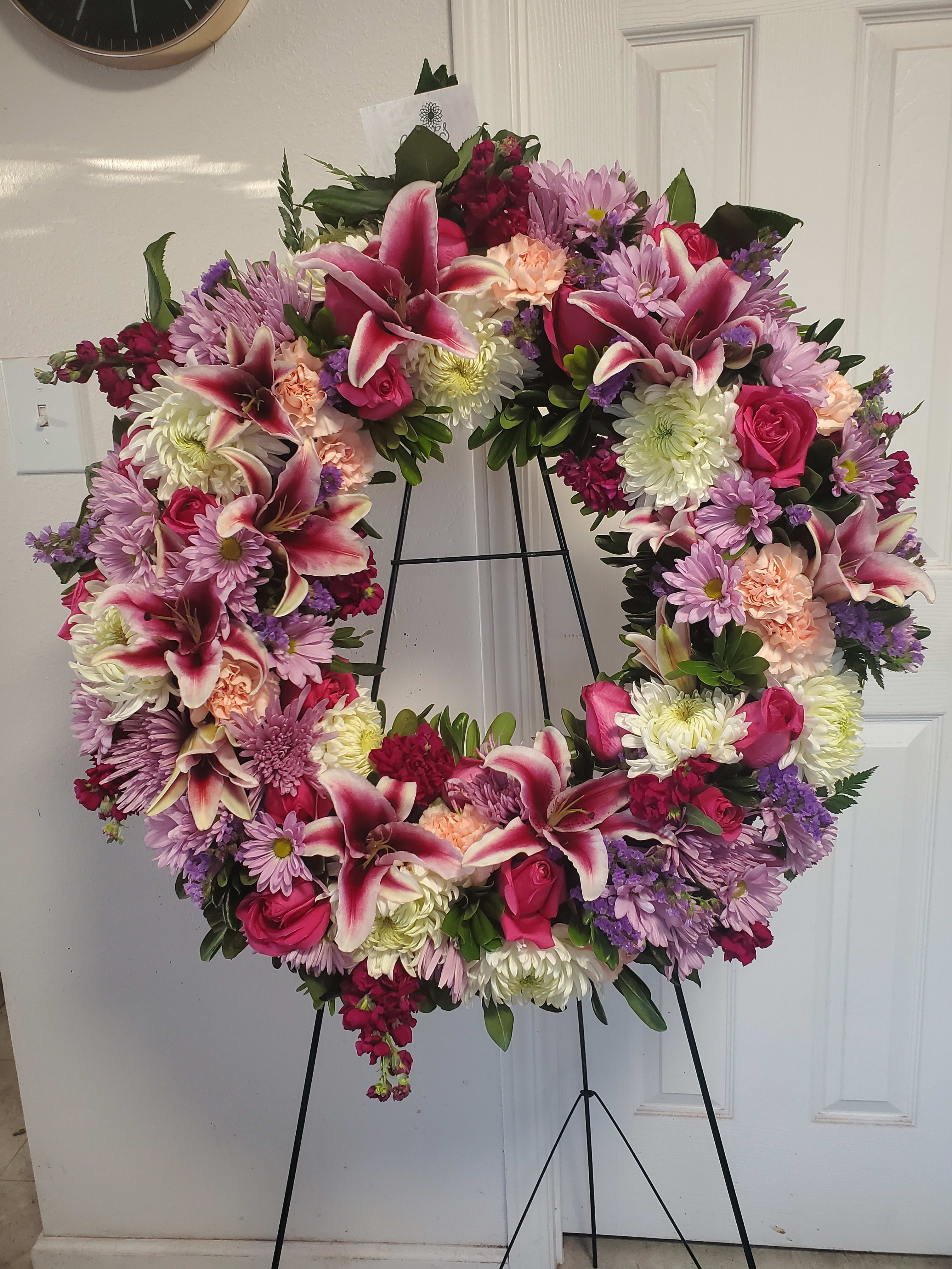 Sweet Lavender Standing Spray - Standing circular spray in various shades of pink and purple which include lilies, football mums, spider mums, carnations, roses, statice, daisies, stargazer, and stock.   (Picture depicts a premium product; standard &amp; deluxe size available upon request)