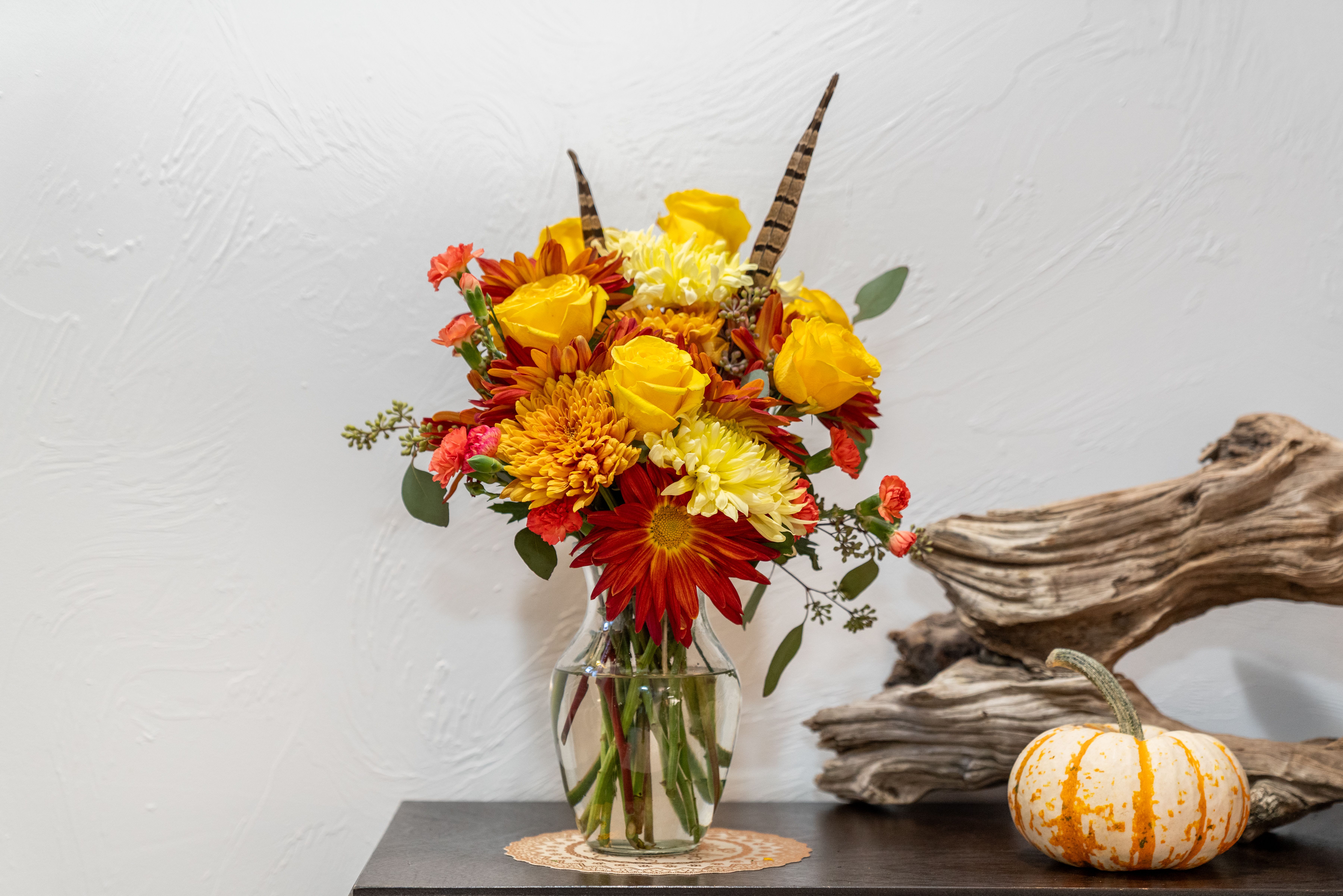 Pleasant Pheasant  Pleasant Pheasant  - This fall arrangement is great for all of your outdoors lovers. Yellow roses, Cremone, and carnations are the stars in this bouquet. The pheasant feathers being the finishing touch.