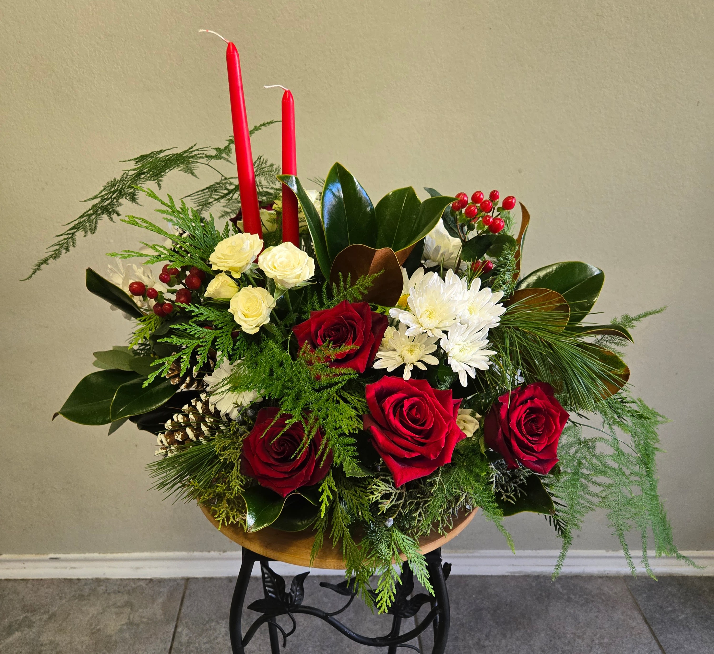 Festive Christmas Centerpiece - This is a beautiful arrangement with red roses, spray roses, eucalyptus, magnolia leaves, hypericum, and mums. Picture depicts premium arrangement. 