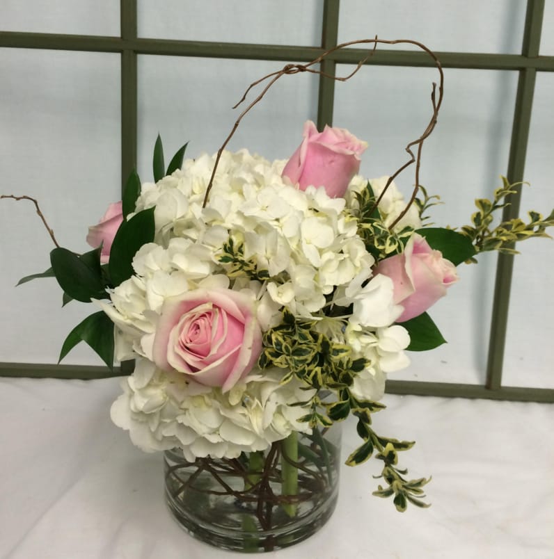 Simply Elegant - This bouquet is simple - White Hydrangeas with an accent of timeless roses of your choice of color.  Texture is added with curly willow and variegated greens. Floral, plant, and hard good substitutions may be made as needed depending on availability. If you have any questions about your order, please call us and we will be happy to speak with you about your selection.