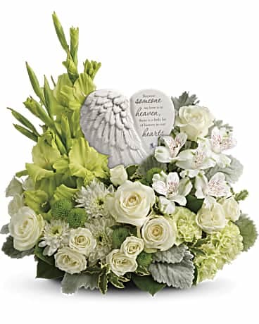 Teleflora's Hearts In Heaven Bouquet - Shades of  White & Green Teleflora's Hearts In Heaven Bouquet - Shades of  White & Green - Share your heart and show your love with this magnificent display of green and white blooms, gracefully surrounding an angel's wing keepsake with a loving message of sympathy. Message on sculpt reads: "Because someone we love is in heaven, there is a little bit of heaven in our hearts."      White spray roses, white alstroemeria, green gladioli, green carnations, green button spray chrysanthemums, and white cushion spray chrysanthemums are accented with dusty miller, pitta negra, and lemon leaf.     Delivered with Teleflora's Heaven's Heart keepsake.     Orientation: One-Sided Floral, plant, and hard good substitutions may be made as needed depending on availability. If you have any questions about your order, please call us and we will be happy to speak with you about your selection.