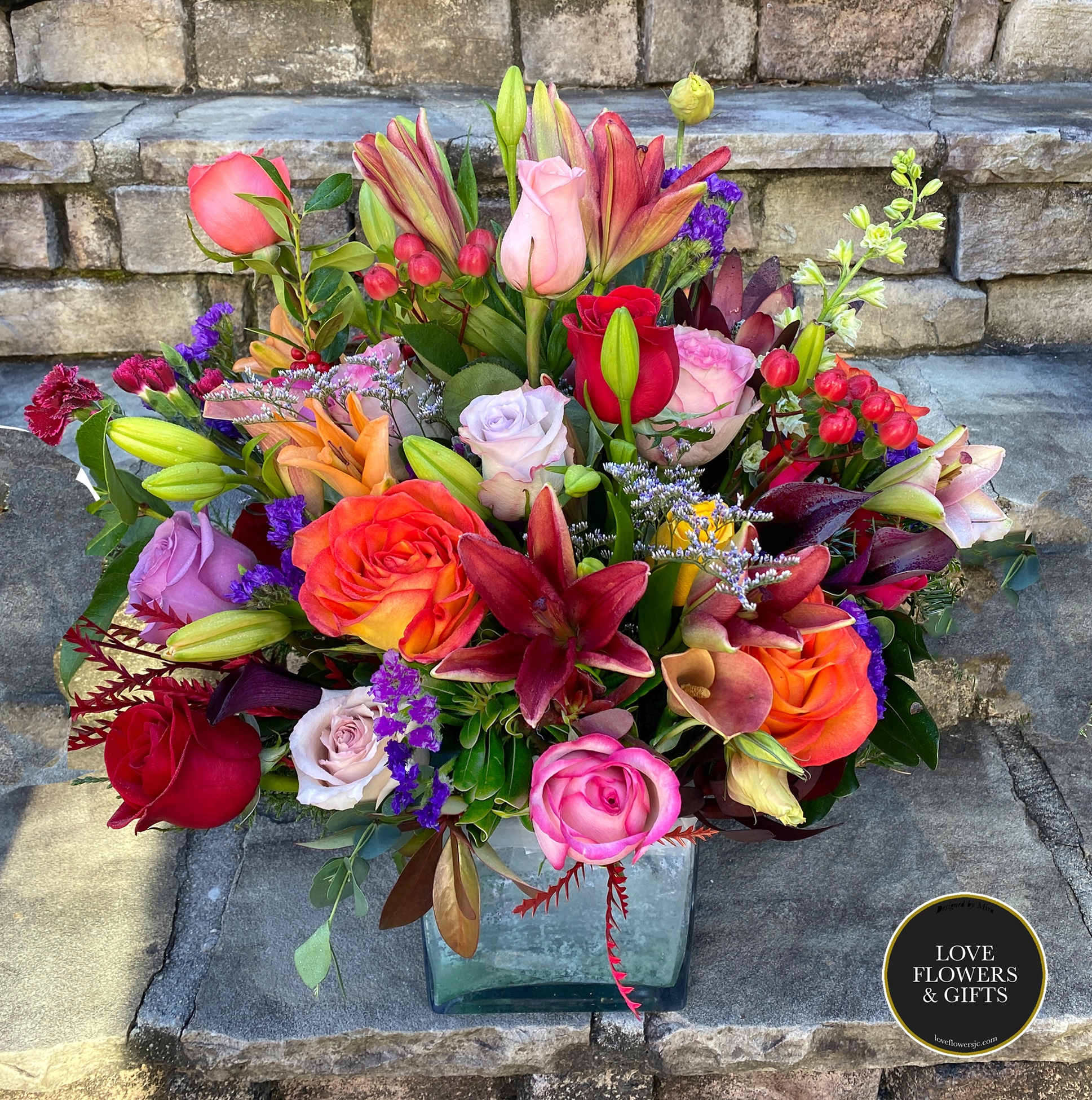 Picasso - A luxurious, sophisticated arrangement designed in a large square glass vase with mixes of various tones.,  Versatile for all kinds of events, including Mother's Day, Birthdays, Anniversary, Congratulations, Grand Openings, New Baby and more. 