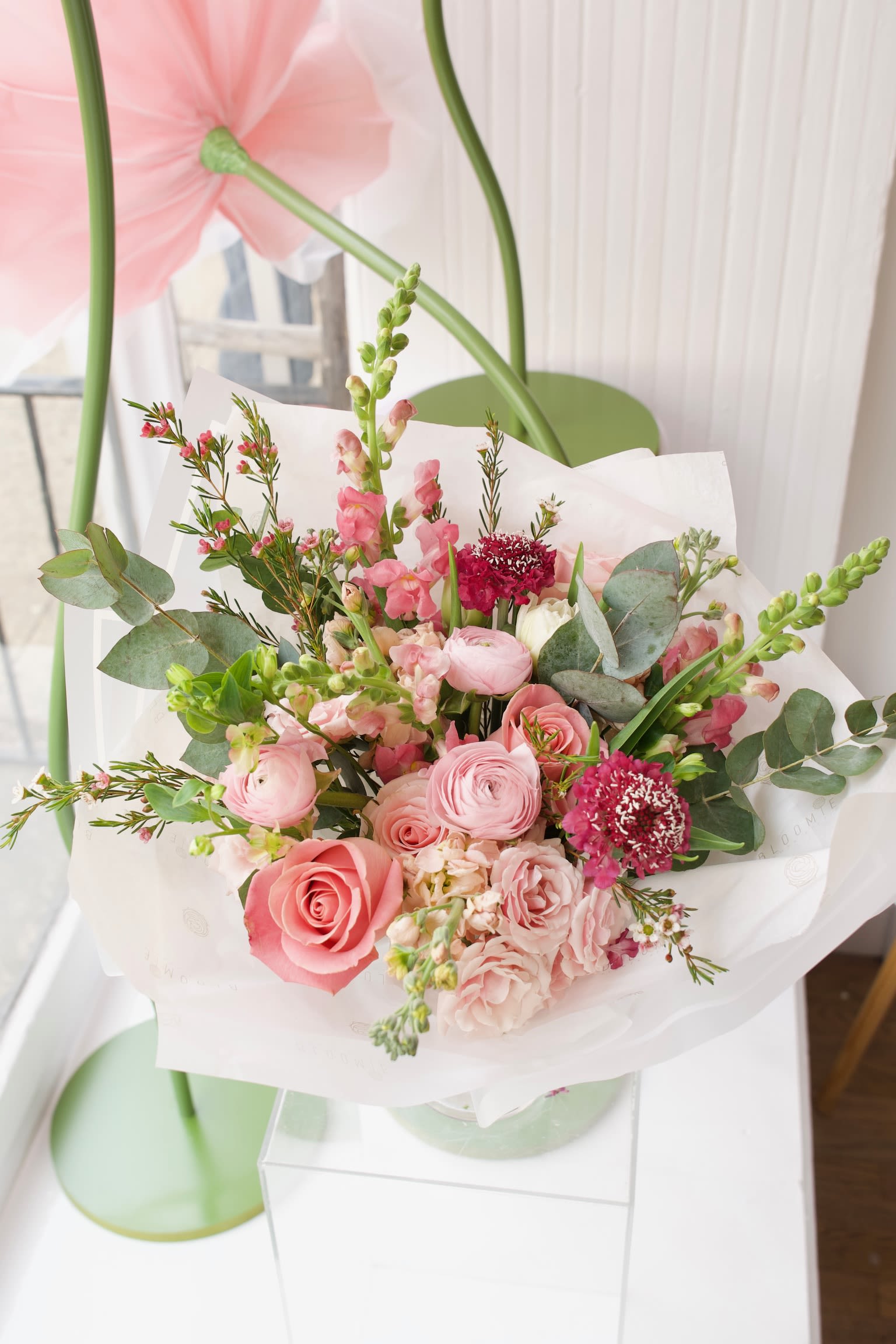 Florist's Choice M - A medium-sized bouquet made with seasonal flowers that are available in our studio. It comes wrapped in paper, and vases are available per request.  Our Florist's Choice arrangements are unique, charming, wild, and always fresh. Please note that flower availability greatly depends on the market and season. Right now you can expect roses, mums, ranunculus, gerberas and various seasonal flowers sourced from local farms. While we can't guarantee exact flower varieties and colors, we ensure top-quality stems and a fresh, beautiful arrangement that you (or your recipient) will adore!