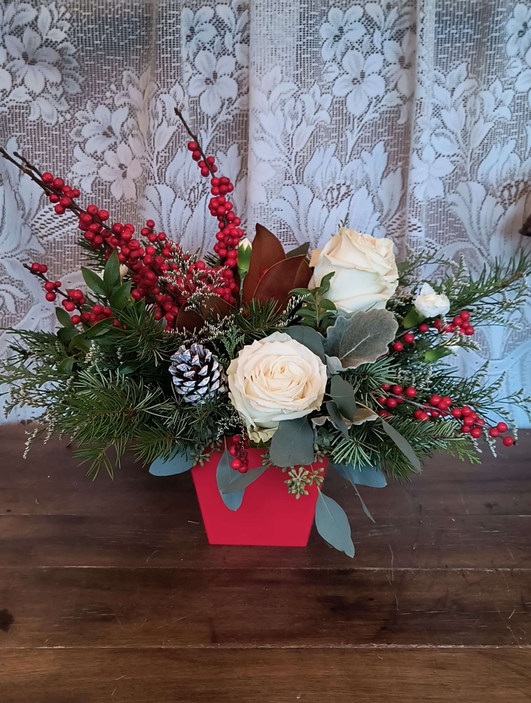 Winter Blooms - Not your everyday centerpiece, this artisanal mix of roses and berries is stylishly presented in a tapered crimson cube.