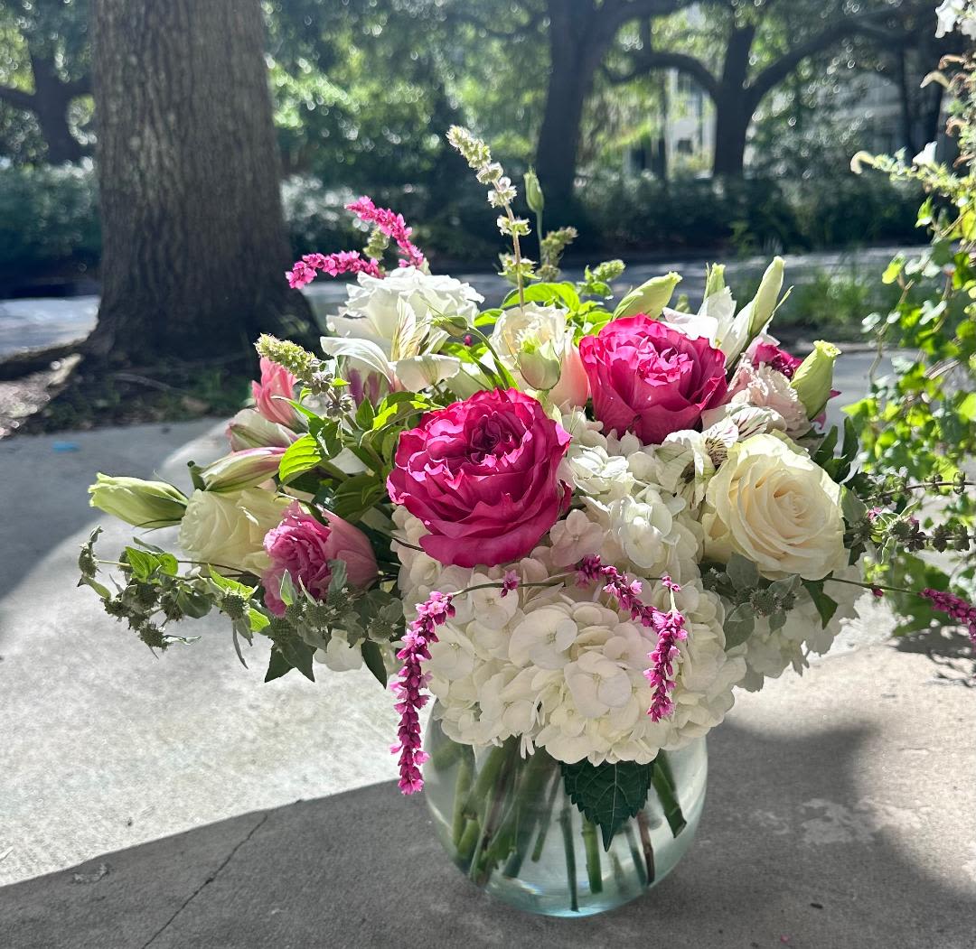 The Cooper  - The cooper features premium flowers such as Hydrangea and Premium roses. These beautiful blooms are accented by delicate greenery and exquisite lisianthus. All these blooms come together in a medium sized Bubble bowl or similar container. This piece is perfect for any dinner table centerpiece or just adorning a counter in any room of any home. (Colors and container may vary). *Shown as Deluxe*