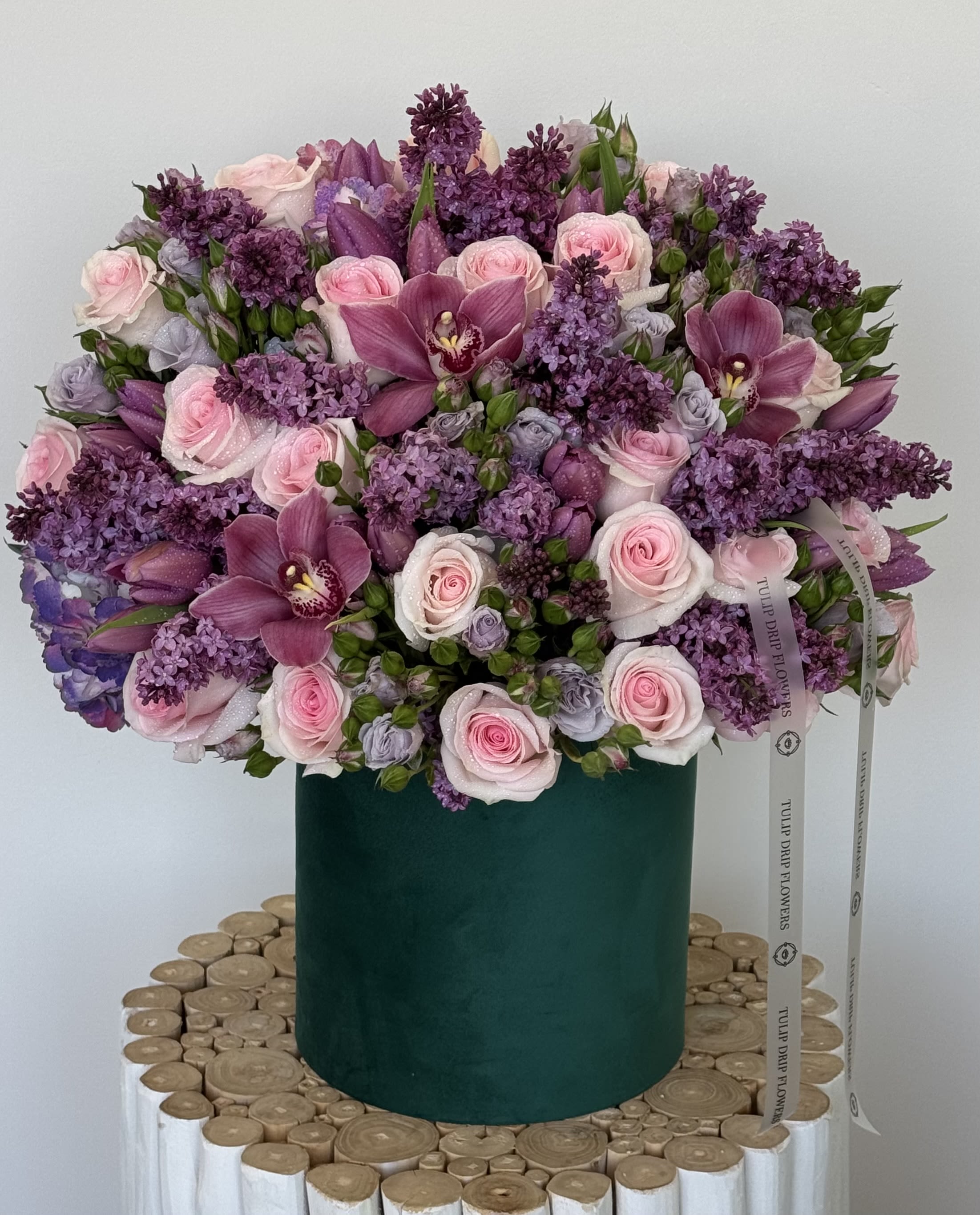 Blushing Garden Mix - A soft, romantic centerpiece filled with blush roses, orchids, and dainty white filler flowers. Designed in a classic garden style, this elegant piece is ideal for moms who love delicate beauty and timeless florals.