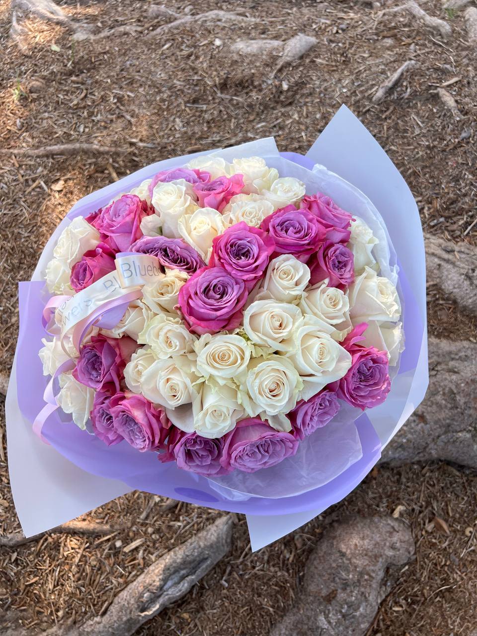 50 White & Purple Roses — Grace and Mystery 50 White & Purple Roses — Grace and Mystery - 50 White & Purple Roses — Grace and Mystery  A breathtaking bouquet of 50 roses in white and purple hues — a harmony of purity and mystery. White roses symbolize sincerity and new beginnings, while purple ones add a touch of royal charm and enchantment. Together, they create a refined and memorable arrangement that speaks the language of deep admiration and elegance.  Perfect for weddings, anniversaries, or to surprise someone with a truly special gesture. Each bouquet is hand-tied with care, ensuring every stem looks flawless.  Details:  50 fresh premium roses in white and purple tones  Hydrated and wrapped for lasting freshness  Signature Bluebell packaging  Available for same-day delivery across Los Angeles