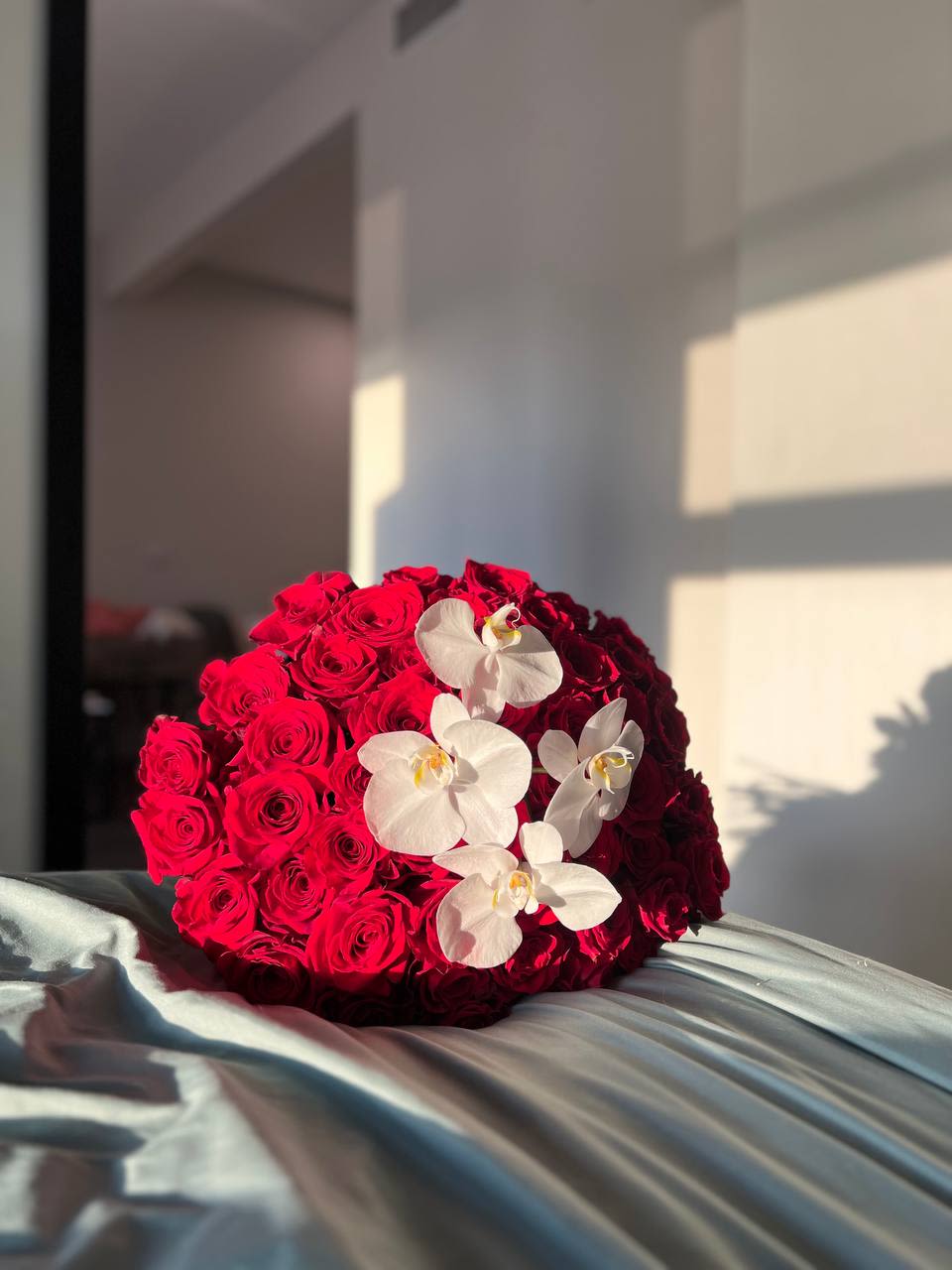 Fiery Elegance Fiery Elegance - Fiery Elegance  This luxurious bouquet is the embodiment of passion and elegance. 50 deep red roses create a rich, striking composition, while a delicate orchid stem adds refinement and grace. The perfect choice to express strong emotions and captivate with its beauty.