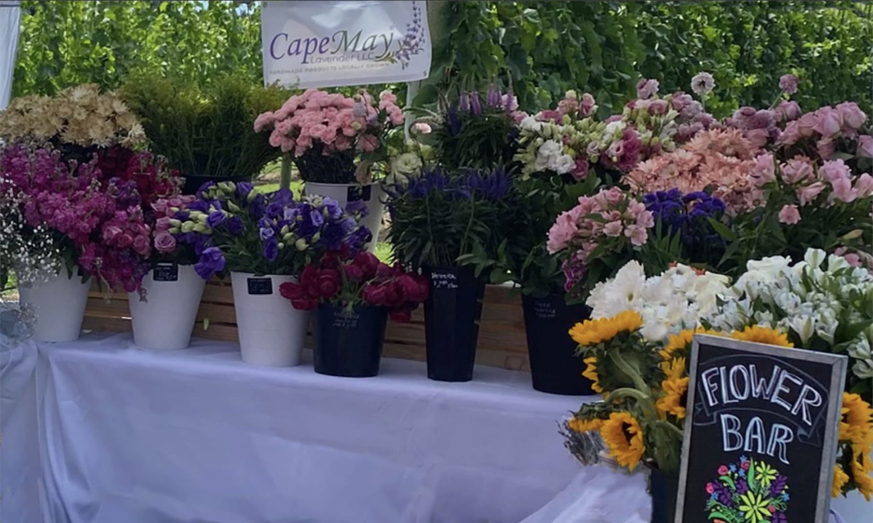 Flower Bar Package (15-30 guests) Regular price starts @  $425.00  Flower Bar Package (15-30 guests) Regular price starts @  $425.00 -  Have an event that everyone will talk about! Now you can have an original flower bar set up a pop-up bouquet station at your event! This package includes approximately 100-300 individual stems, and is perfect for parties of 15-30 guests (will create 15-30  bouquets, each with 3-6 blooms, filler and greenery). Perfect for birthdays, baby showers, corporate events, bridal showers, or parties of all types!  choose floral color and we do the rest. Set up and take away is $100.. or pick up all supplies yourself for free.  All buckets, crates, tablecloths, and scissors/snips are considered rentals. All flowers, ribbons, stickers and packaging are yours to keep.    If you would like to have the designer there to help wrap bouquets there is an additional charge of $ 90 per hour for up to 3 hours.  ***pictured is the largest set up/. smaller buckets will be used for the smaller petit set up