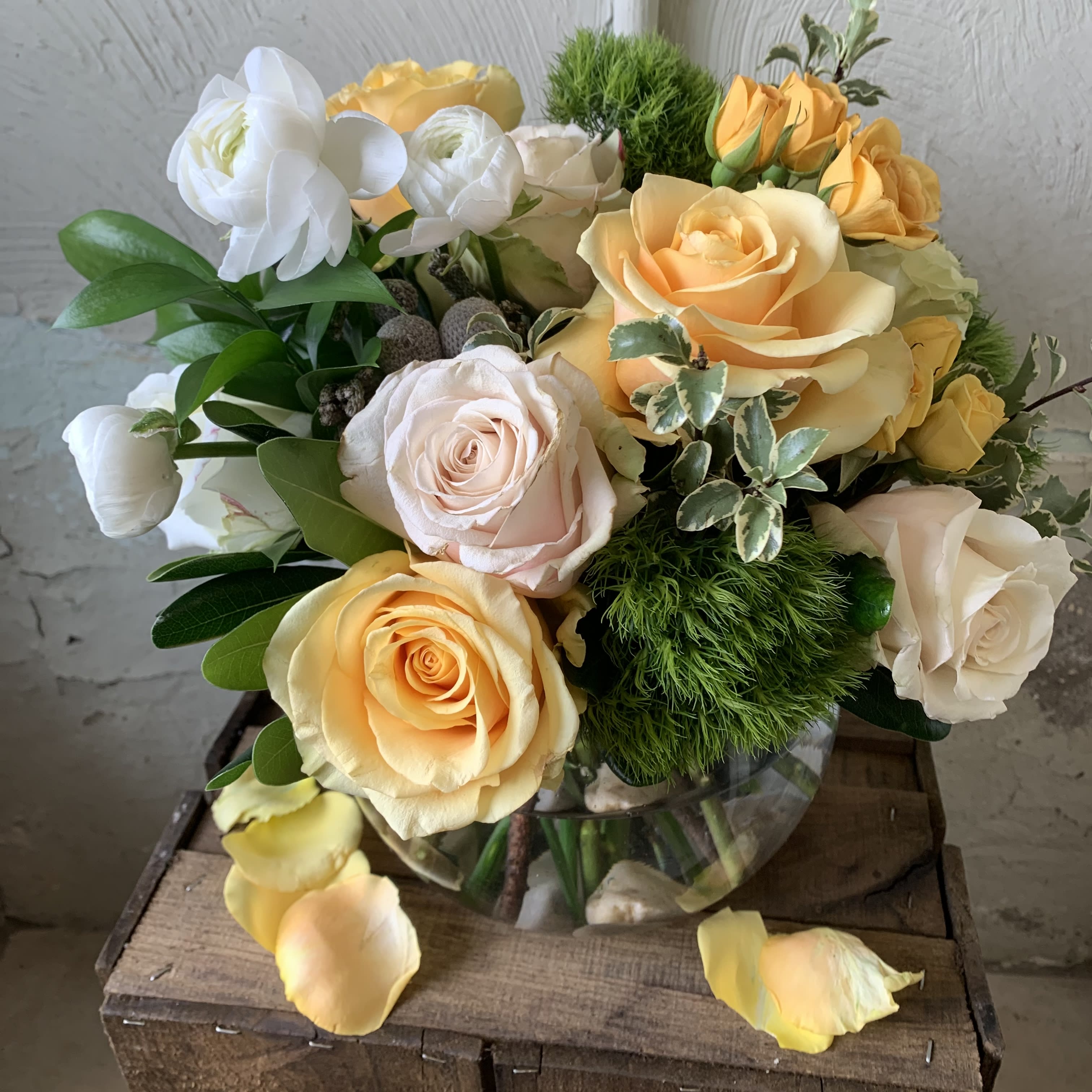 Butter &amp; Cream - A soft mix of pale yellow roses and creamy blooms accented with soft greens and designed elegantly in a premium glass vase. 