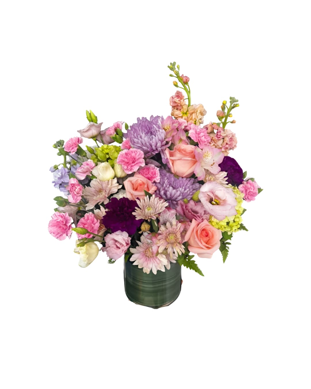 Blush daydream - A dreamy pastel arrangement designed in a modern green glass vase. Featuring roses, lisianthus, mums, carnations, stock, alstroemeria, and touches of greens, this bouquet blends shades of soft pink, lilac, cream, and deep plum for contrast. Perfect for birthdays, “thinking of you,” or simply to brighten a room with gentle elegance.  Note: Certain flowers may be replaced with equal-value seasonal blooms to ensure freshness and quality.