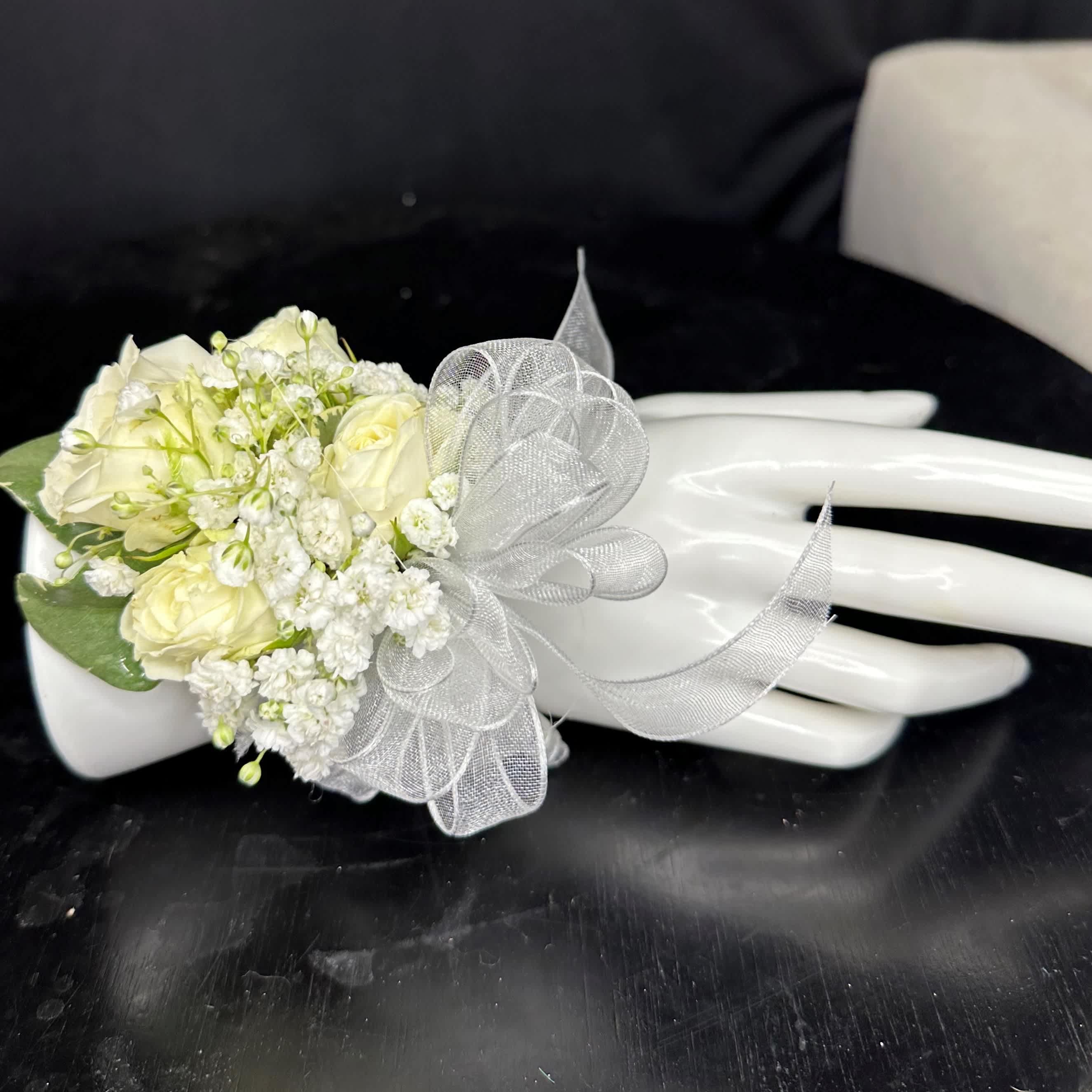 White Rose Corsage White Rose Corsage - Create a stunning accent for your special occasion with this exquisite white rose corsage. Utilize the special instructions to select the perfect ribbon color, allowing you to customize this accessory to match your desired aesthetic or event theme. Whether you opt for a classic ivory, a bold red, or a delicate blush pink, let the chosen ribbon complement the elegance of the white rose, enhancing the beauty of your ensemble with a personal touch.